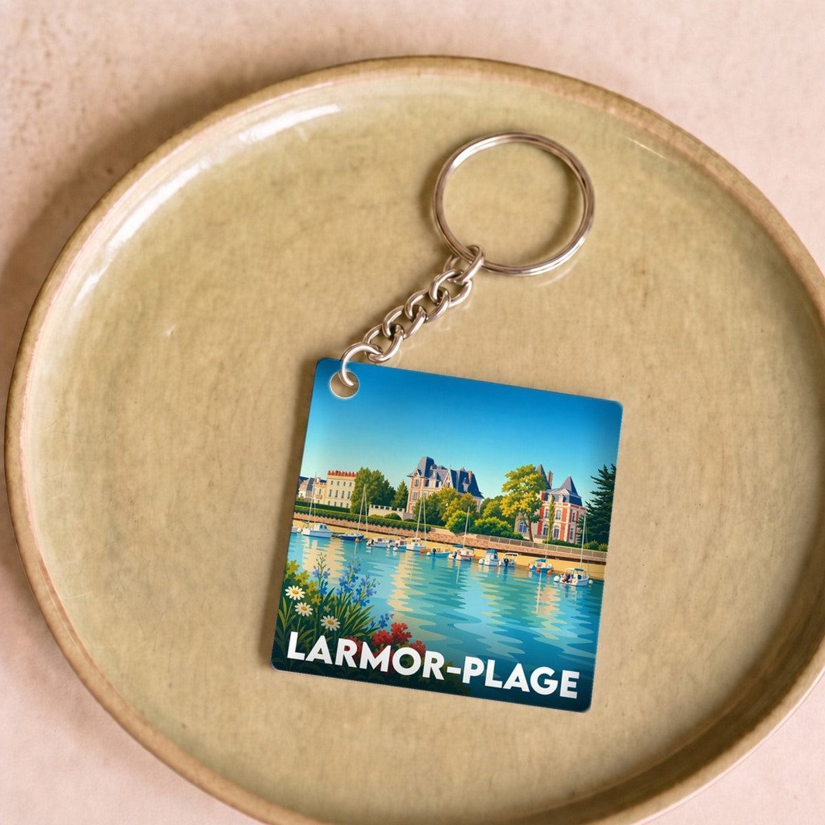 Porte-clés souvenir de la ville de Larmor-Plage avec une illustration stylisée du bord de mer.