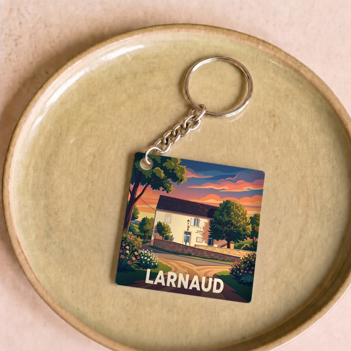 Porte-clés souvenir de la ville de Larnaud avec une illustration stylisée.