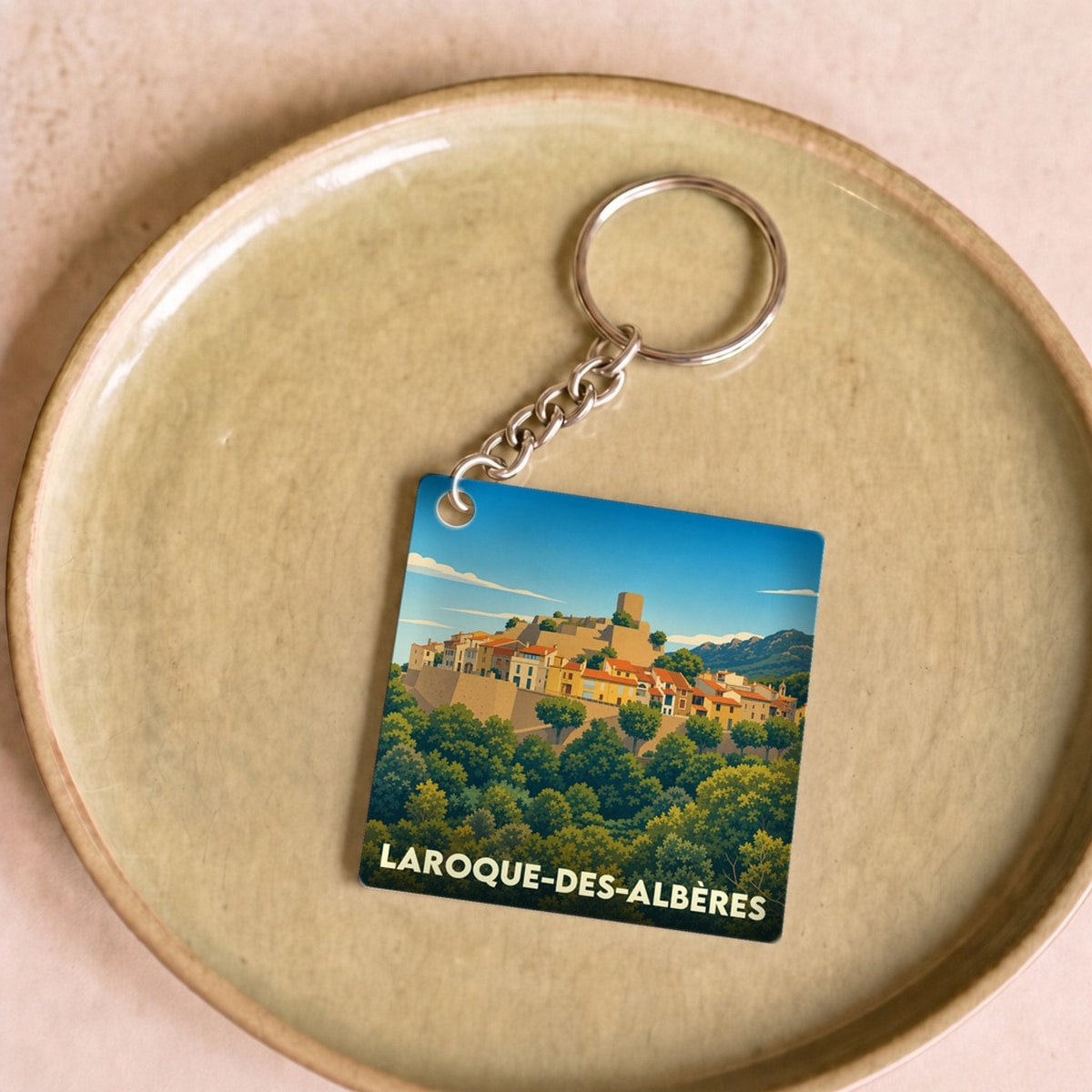 Porte-clés souvenir de la ville de Laroque-des-Albères avec une illustration stylisée.