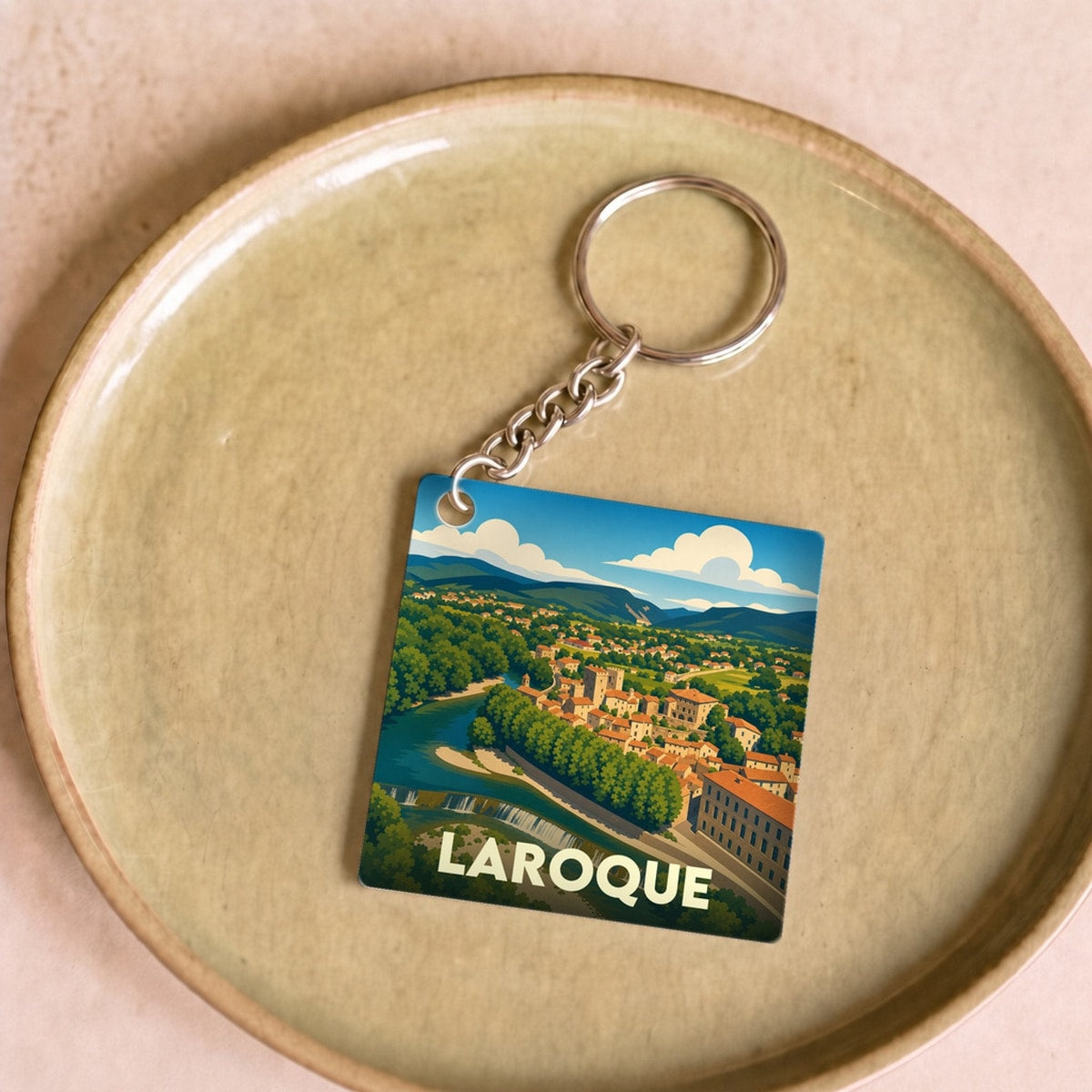 Porte-clés souvenir de la ville de Laroque avec une illustration stylisée.