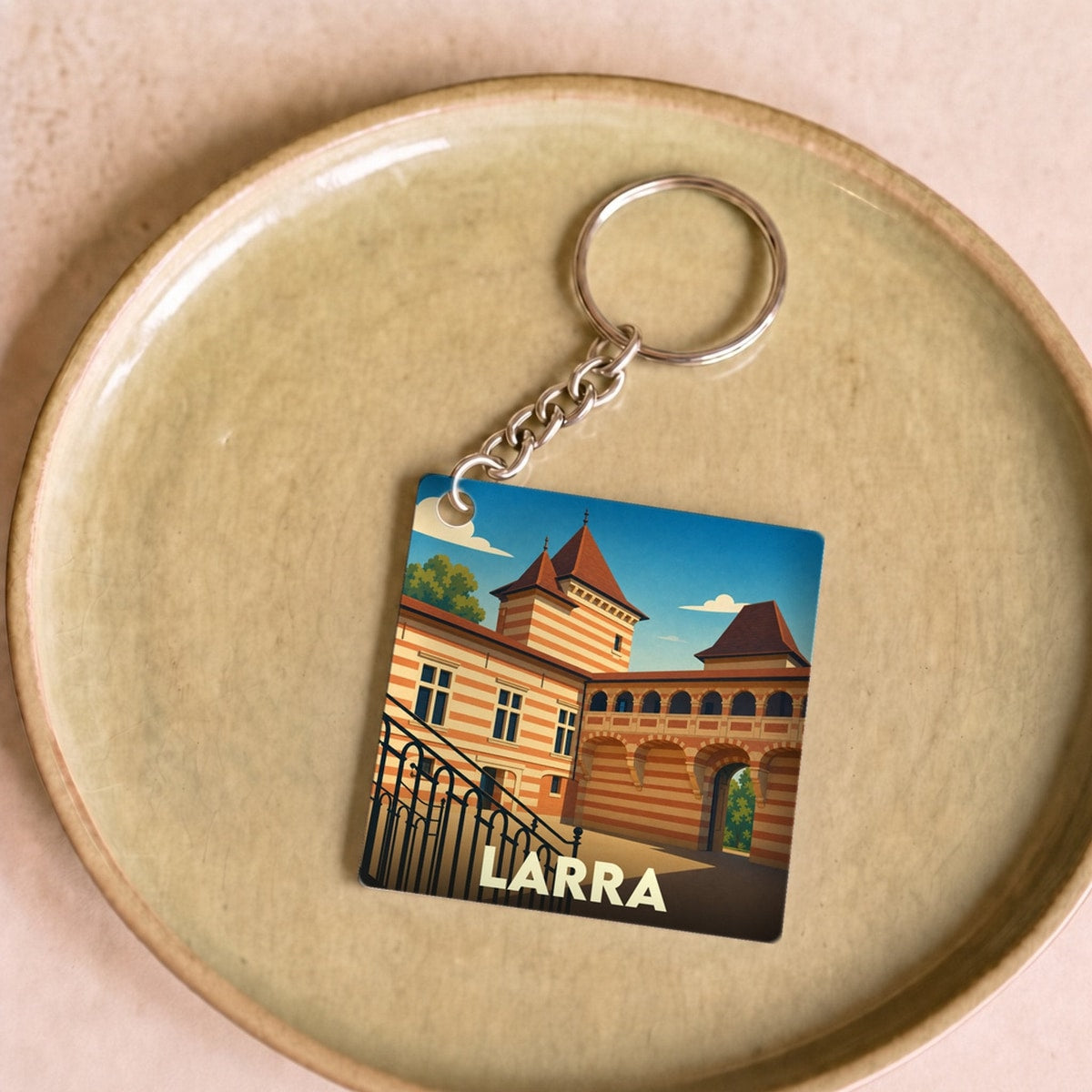 Porte-clés souvenir de la ville de Larra avec une illustration stylisée de son château.