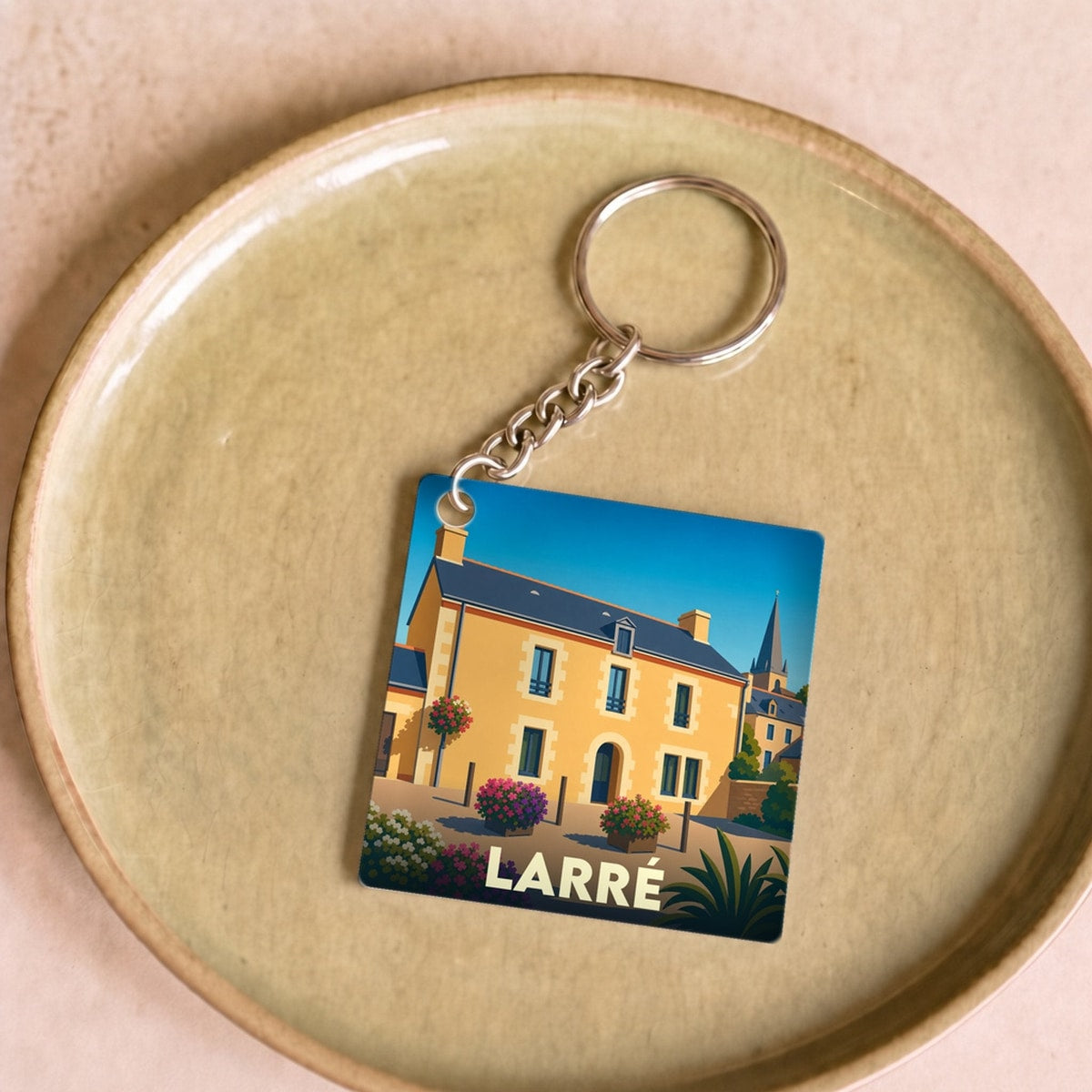 Porte-clés souvenir de la ville de Larré avec une illustration stylisée d'un bâtiment traditionnel.