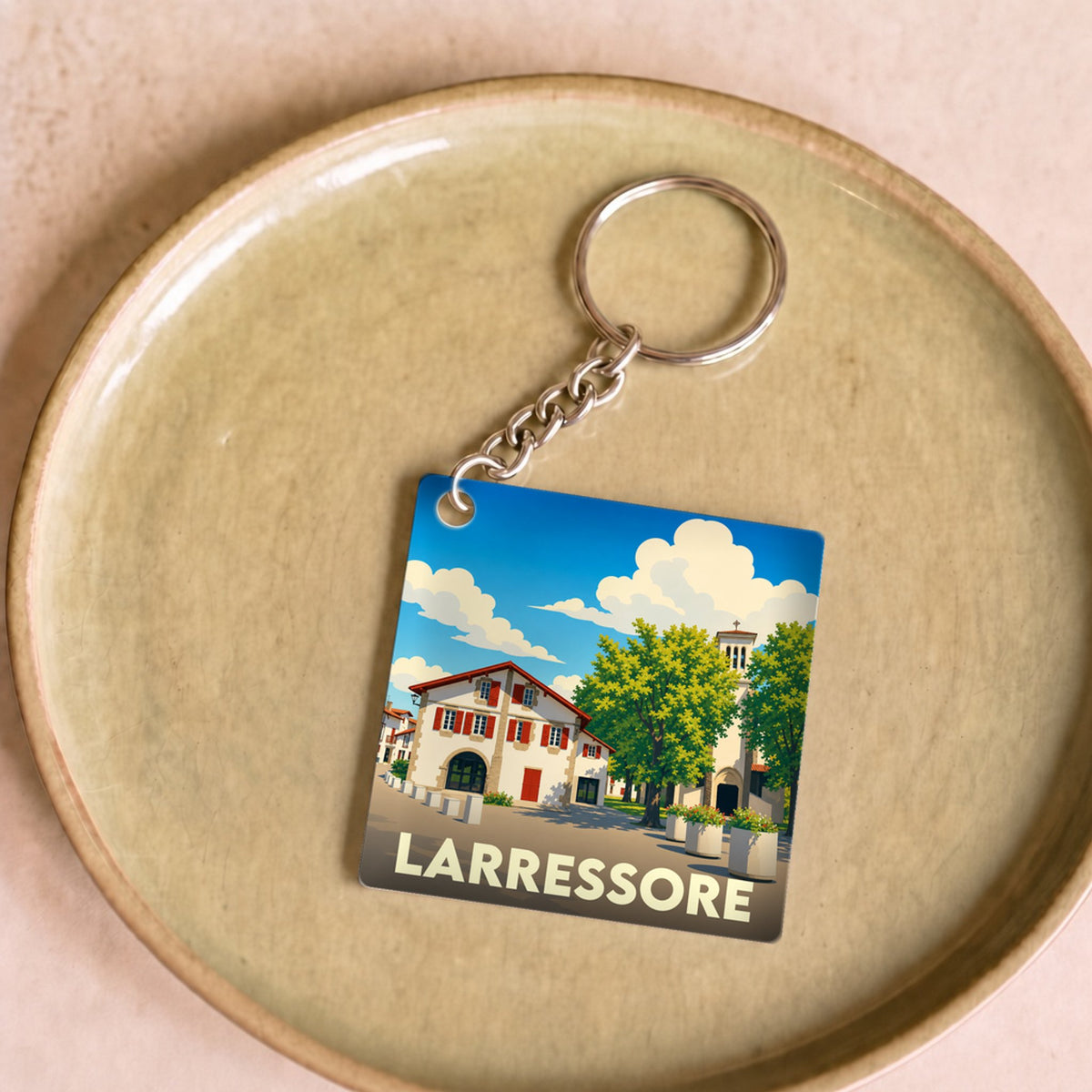 Porte-clés souvenir de la ville de Larressore avec une illustration stylisée.