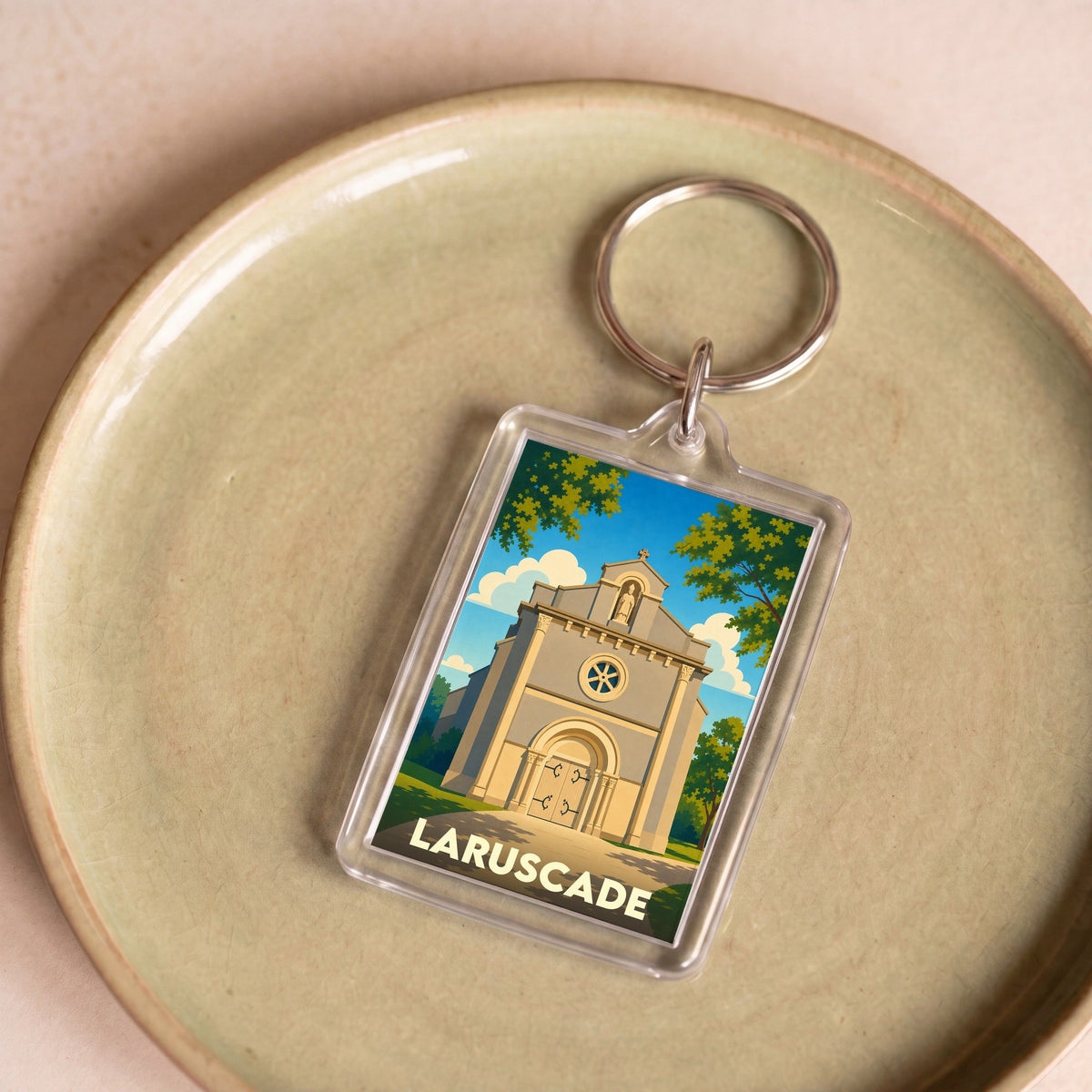 Porte-clés souvenir de la ville de Laruscade avec une illustration stylisée de son église.