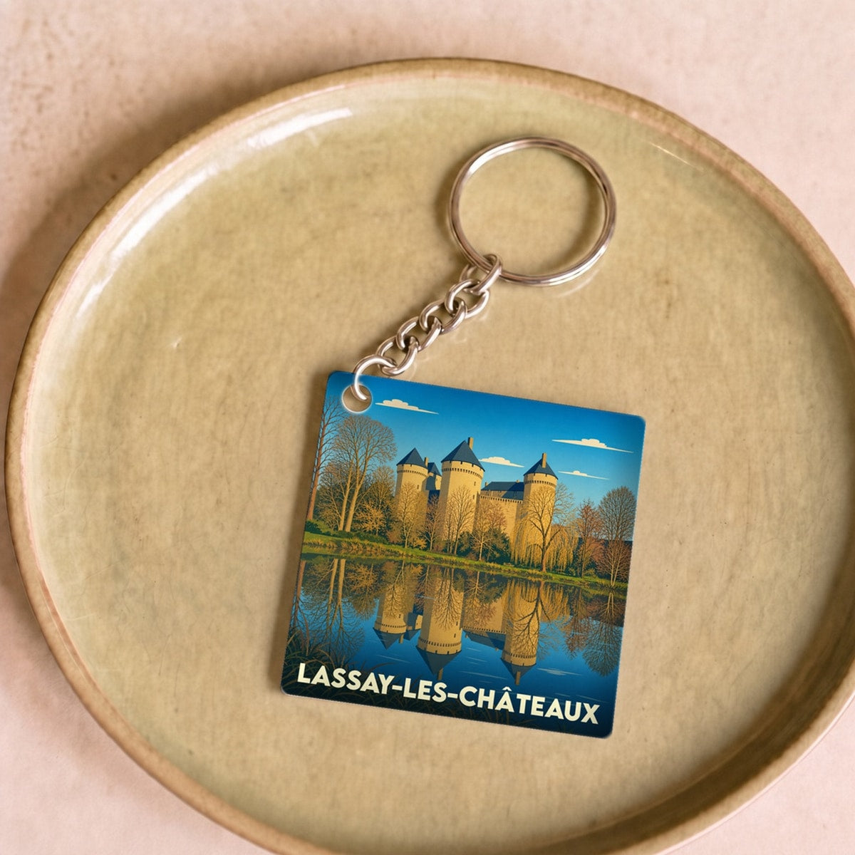 Porte-clés souvenir de la ville de Lassay-les-Châteaux avec une illustration stylisée.