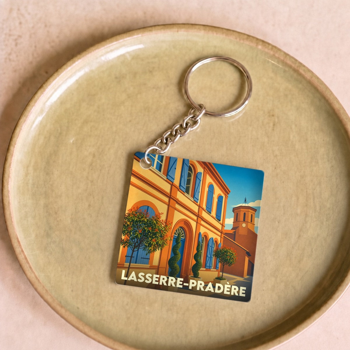 Porte-clés souvenir de la ville de Lasserre-Pradère avec une illustration colorée et stylisée.
