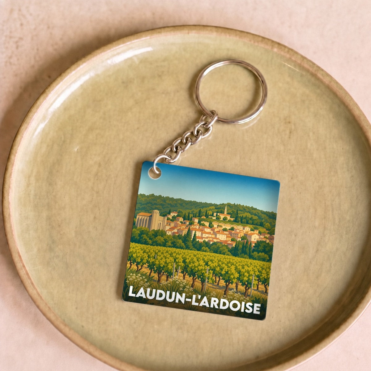 Porte-clés souvenir de la ville de Laudun-l'Ardoise avec une illustration stylisée.