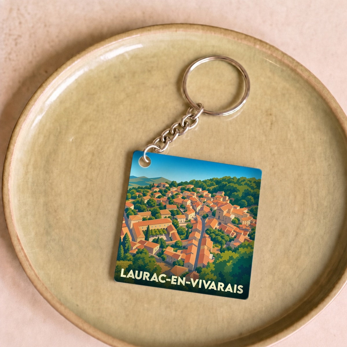 Porte-clés souvenir de Laurac-en-Vivarais avec une illustration stylisée du village.