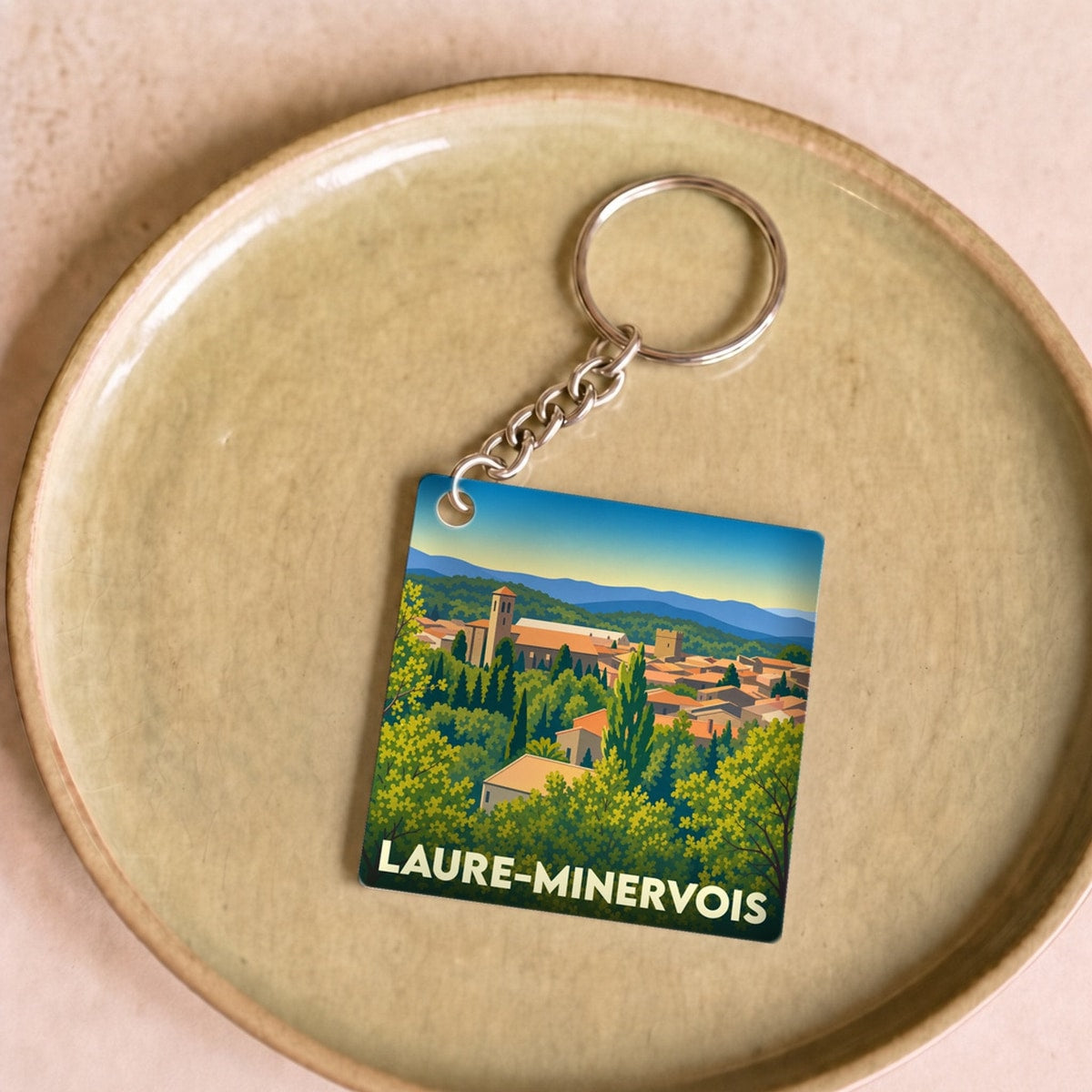 Porte-clés souvenir de la ville de Laure-Minervois avec une illustration stylisée.