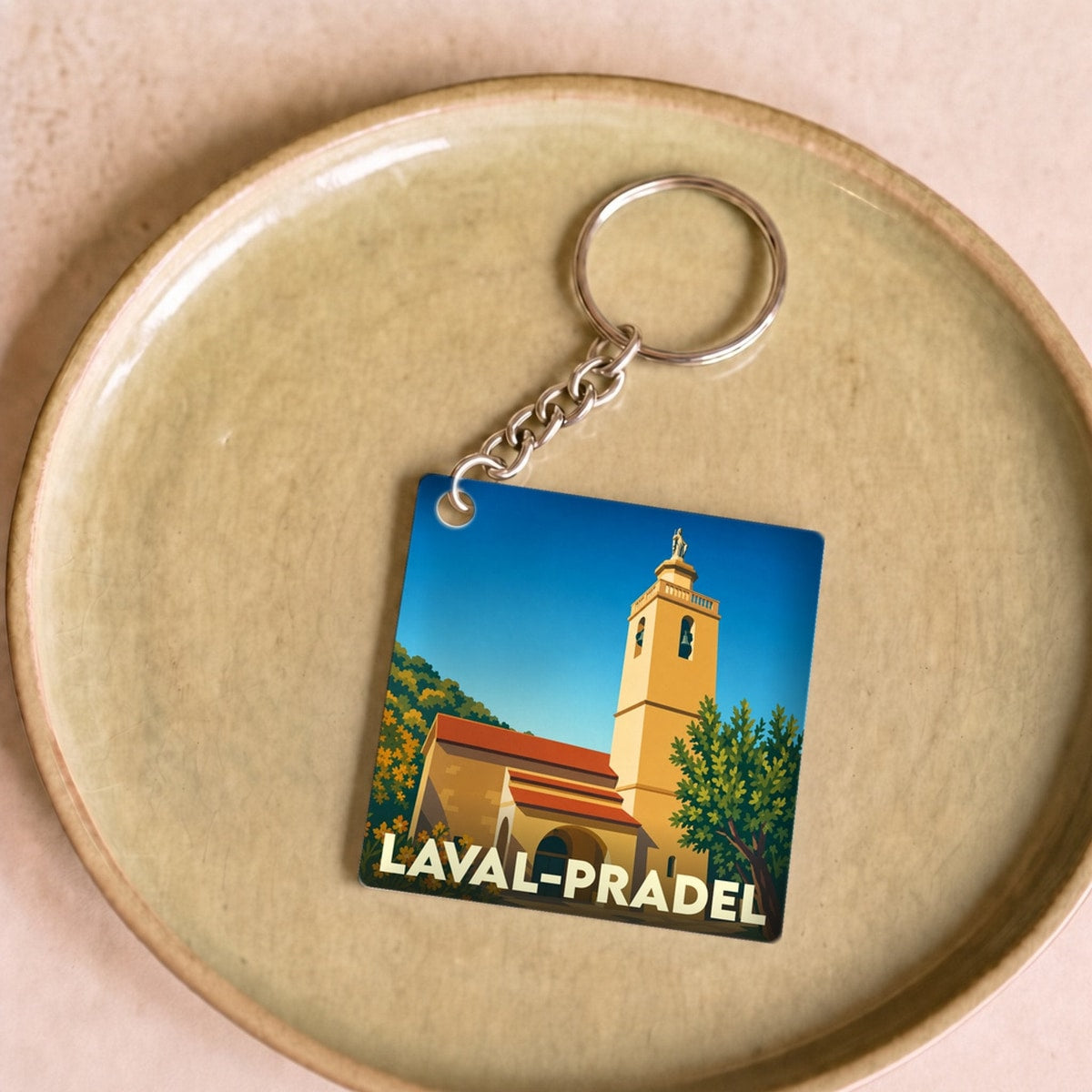 Porte-clés souvenir de la ville de Laval-Pradel avec une illustration stylisée.