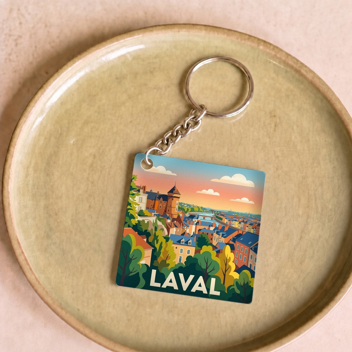 Porte-clés souvenir de la ville de Laval avec une illustration stylisée du paysage urbain.