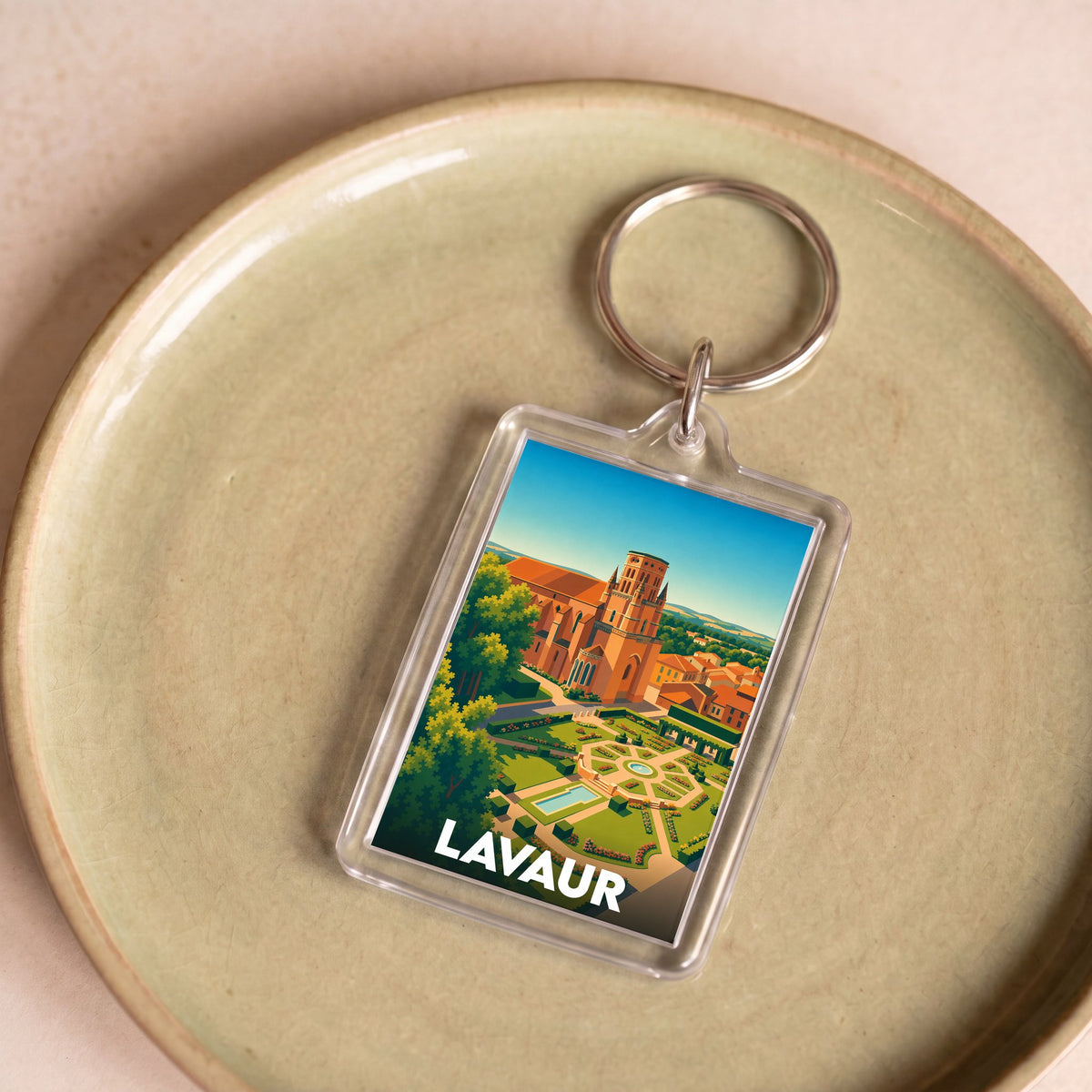 Porte-clés souvenir de la ville de Lavaur avec une illustration stylisée de sa cathédrale et de ses jardins.
