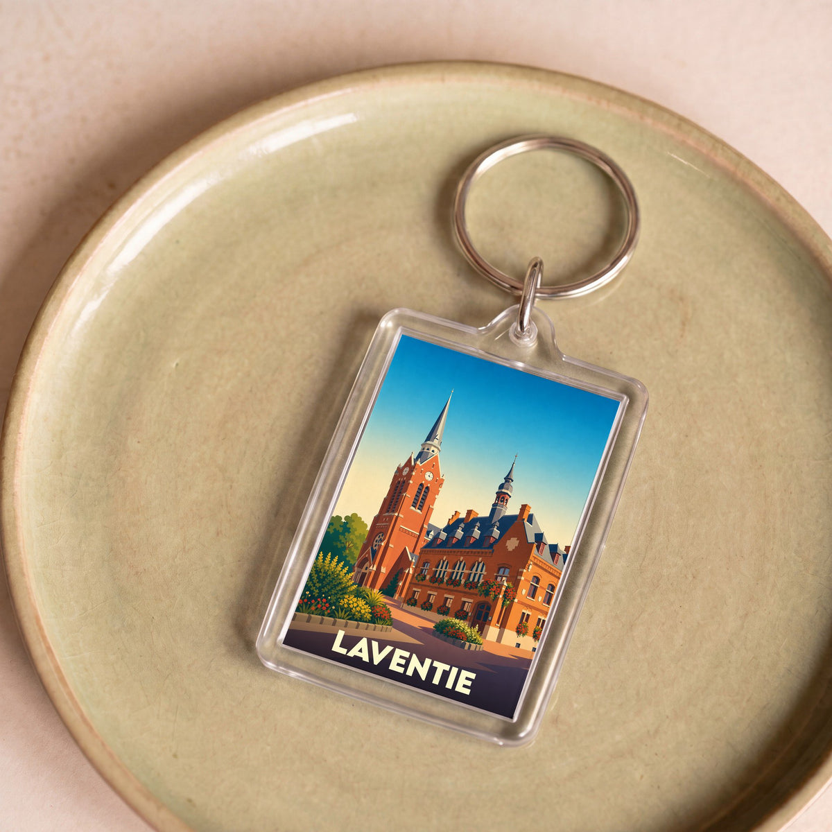 Porte-clés souvenir de la ville de Laventie avec une illustration stylisée de son architecture.
