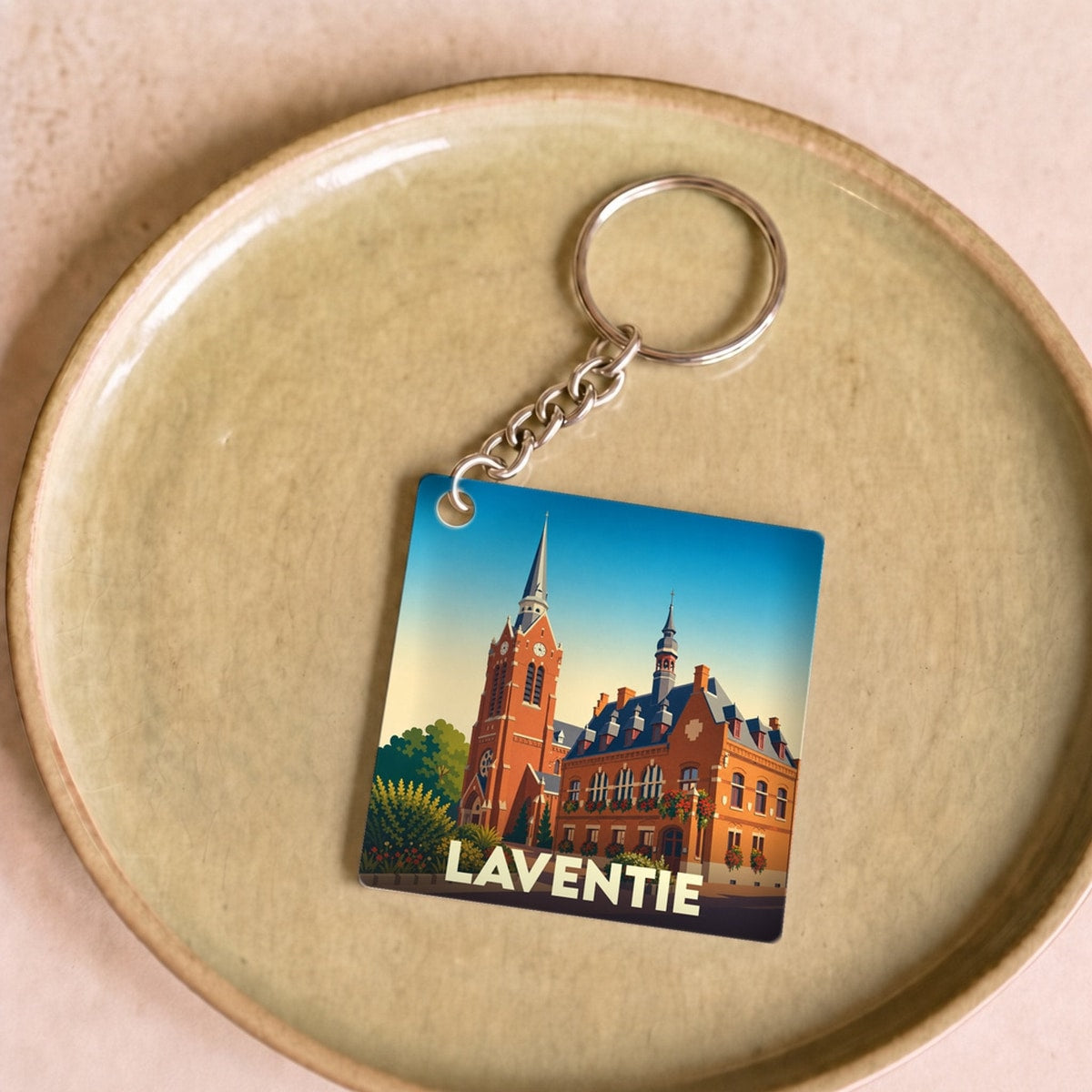 Porte-clés souvenir de la ville de Laventie avec une illustration stylisée de son architecture.
