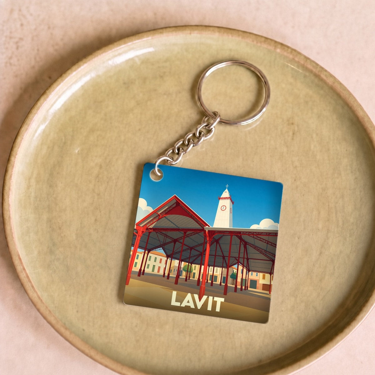 Porte-clés souvenir de la ville de Lavit avec une illustration stylisée de sa halle et de son clocher.