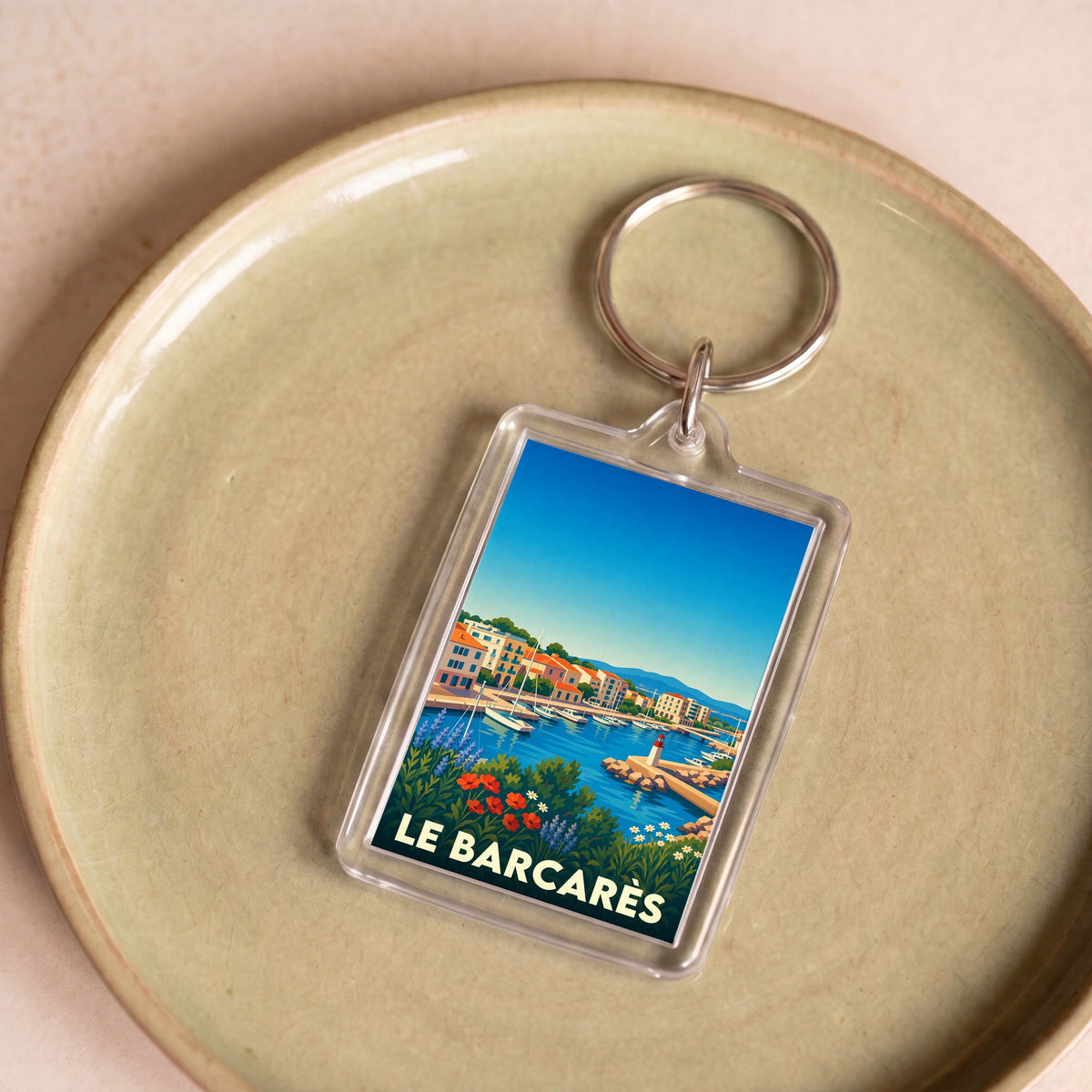 Porte-clés souvenir de la ville de Le Barcarès avec une illustration stylisée du port.