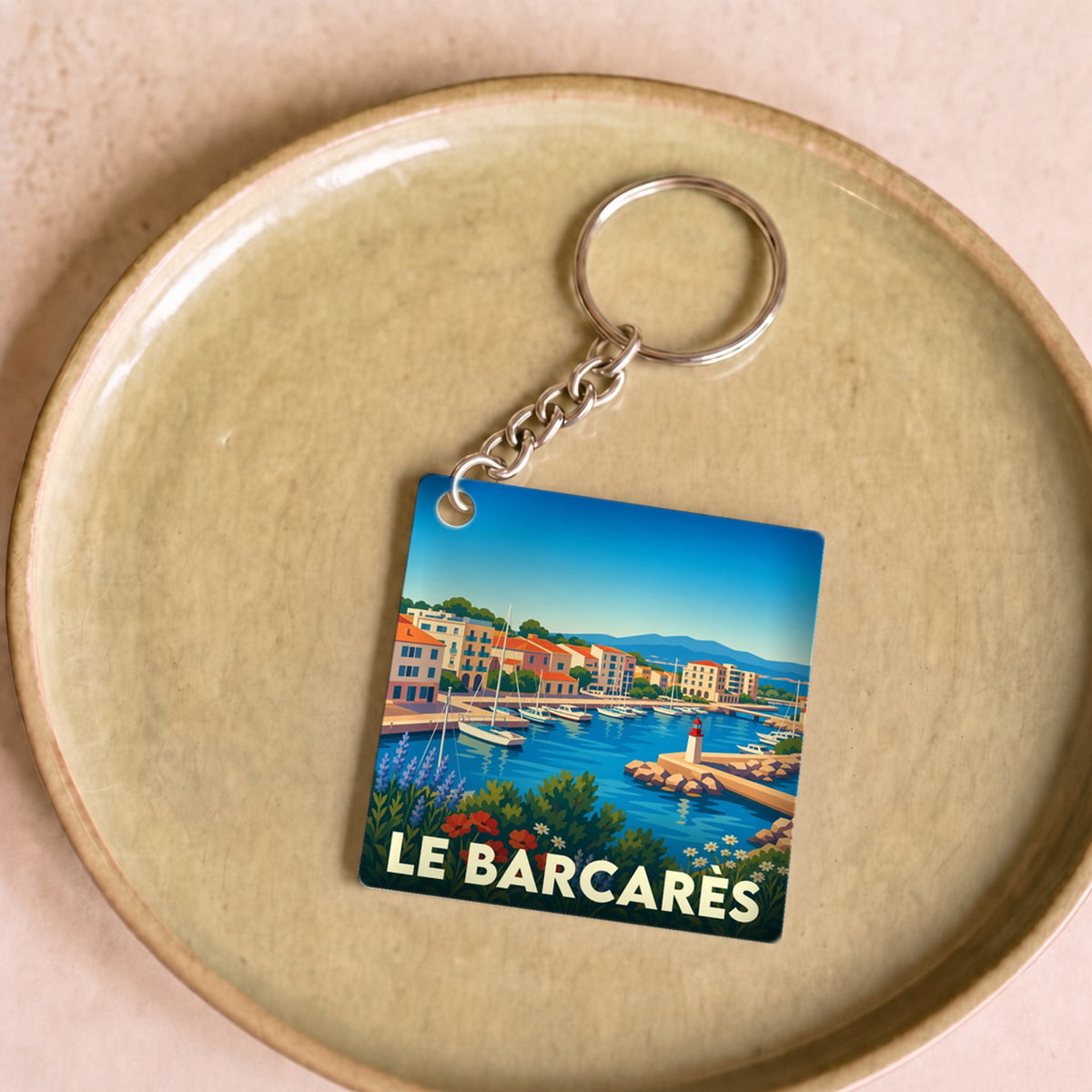Porte-clés souvenir de la ville de Le Barcarès avec une illustration stylisée du port.
