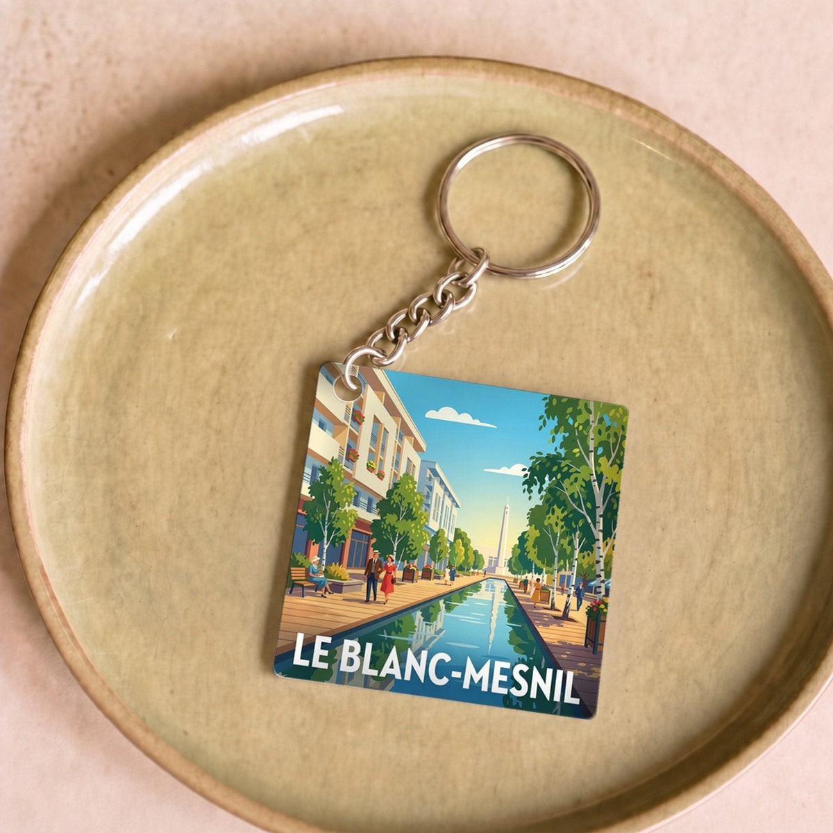 Porte-clés souvenir de la ville de Le Blanc-Mesnil avec une illustration stylisée.