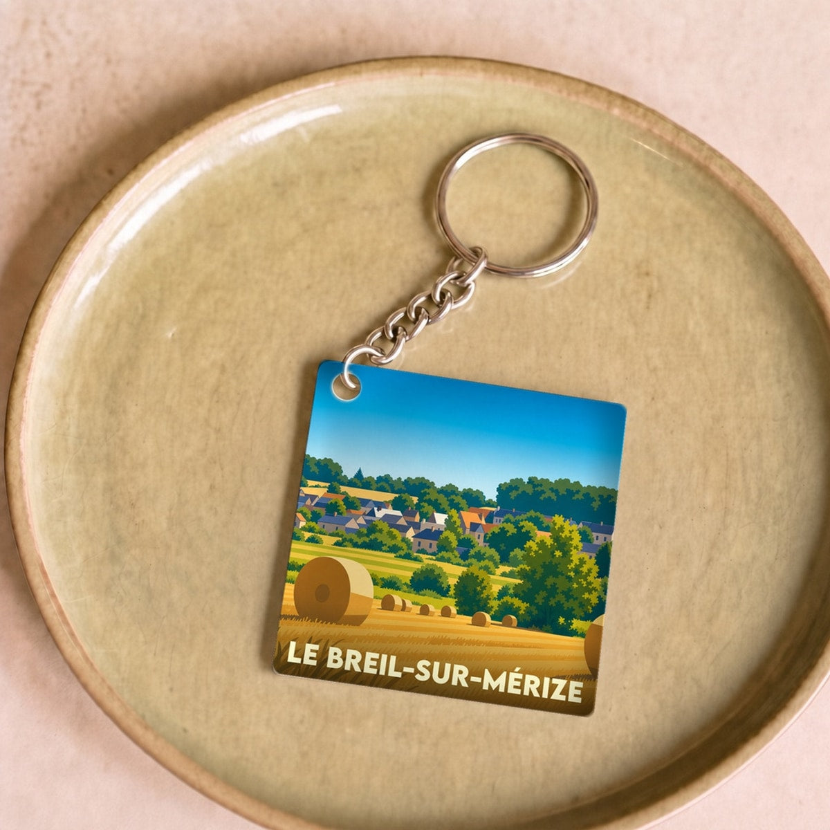 Porte-clés souvenir de la ville de Le Breil-sur-Mérize avec une illustration stylisée de champs de blé.