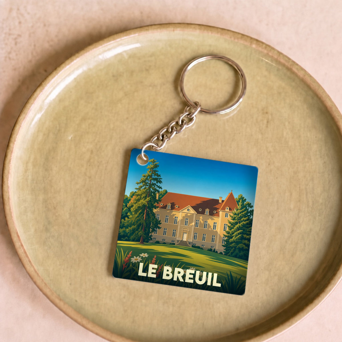 Porte-clés souvenir de la ville de Le Breuil avec une illustration stylisée de son château.
