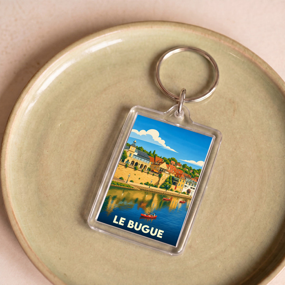 Porte-clés souvenir de la ville du Bugue avec une illustration stylisée des bords de la Vézère.
