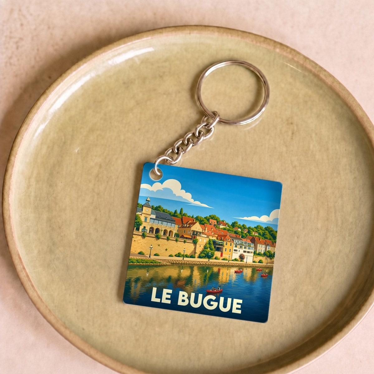 Porte-clés souvenir de la ville du Bugue avec une illustration stylisée des bords de la Vézère.