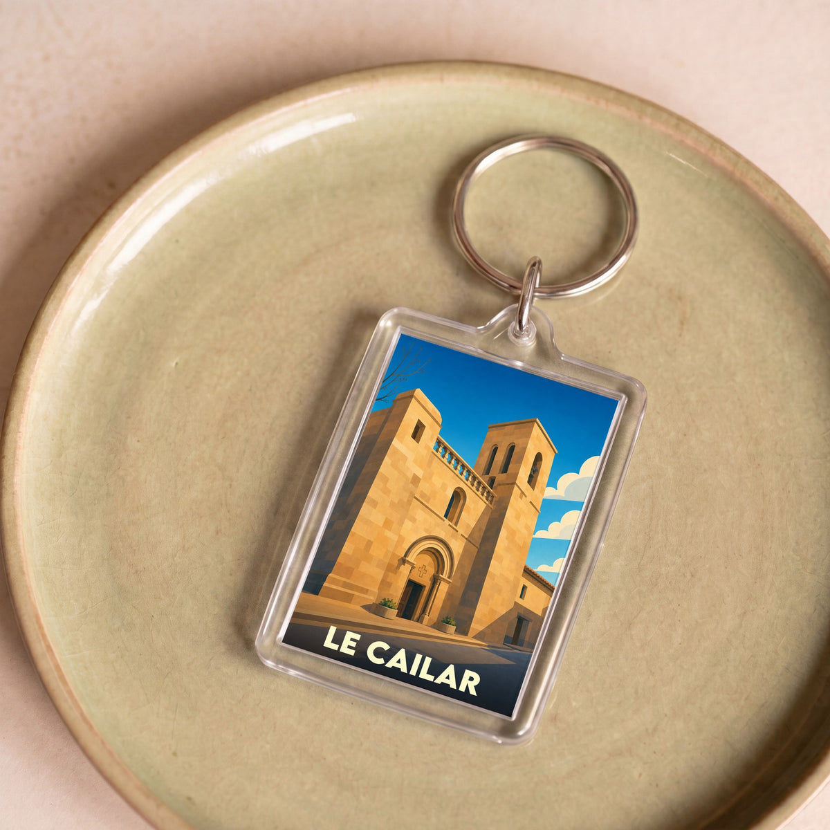 Porte-clés souvenir de la ville de Le Cailar avec une illustration stylisée de son église.
