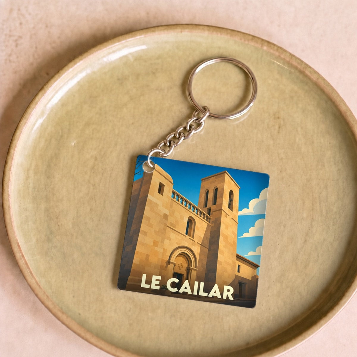 Porte-clés souvenir de la ville de Le Cailar avec une illustration stylisée de son église.
