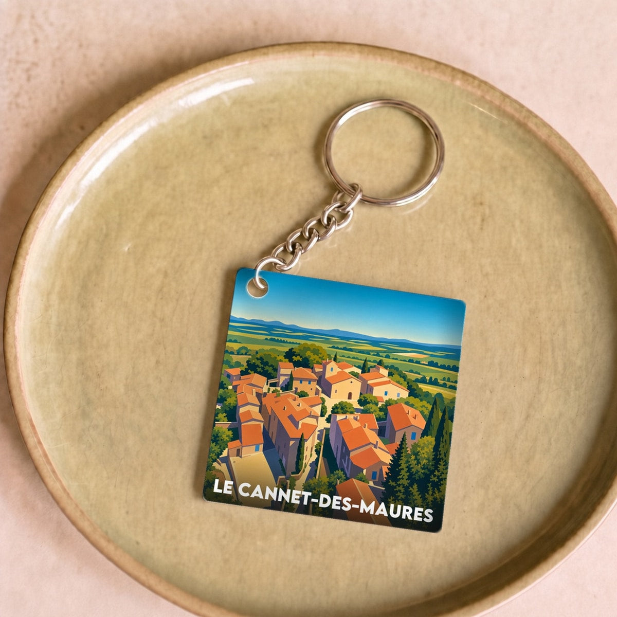 Porte-clés souvenir de la ville de Le Cannet-des-Maures avec une illustration stylisée.