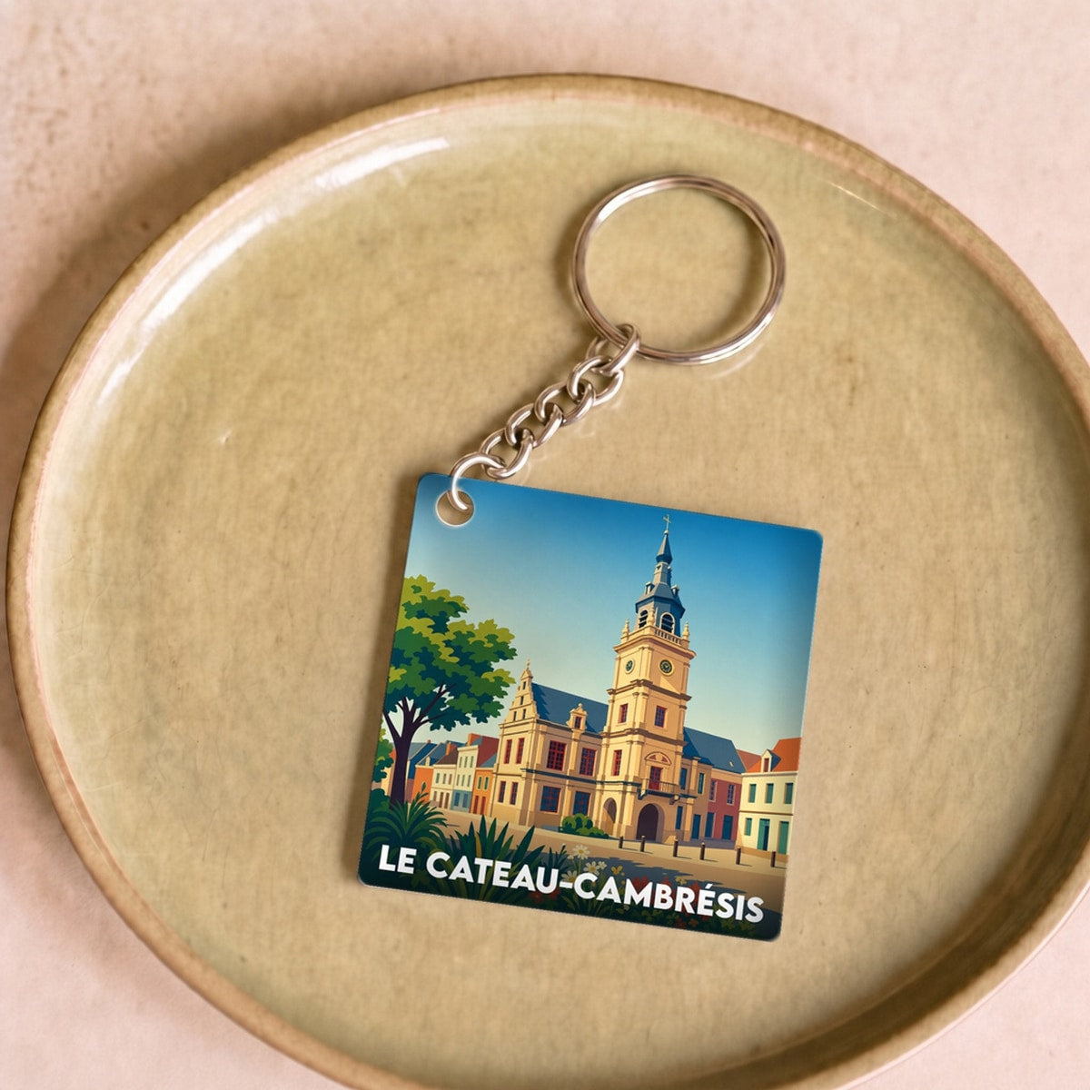Porte-clés souvenir de la ville de Le Cateau-Cambrésis avec une illustration stylisée.
