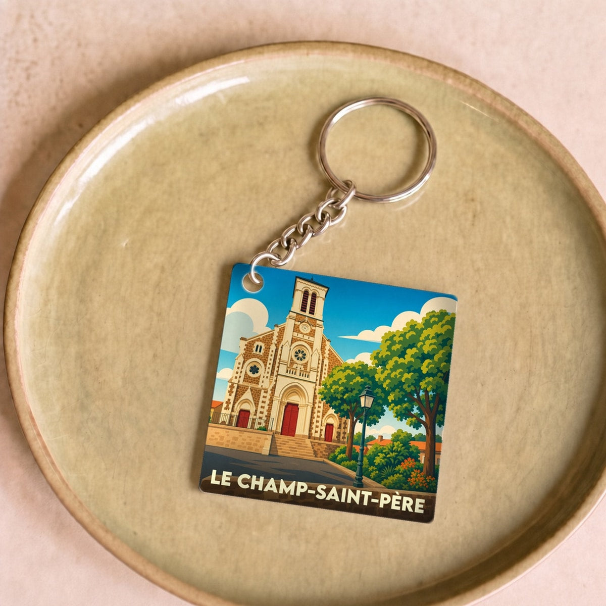 Porte-clés souvenir de la commune de Le Champ-Saint-Père avec une illustration stylisée de son église.