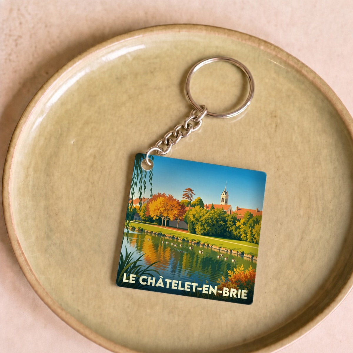 Porte-clés souvenir de la ville du Châtelet-en-Brie avec une illustration stylisée de ses paysages.