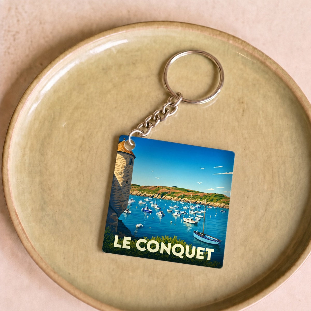 Porte-clés souvenir de la ville de Le Conquet avec une illustration stylisée de son port.