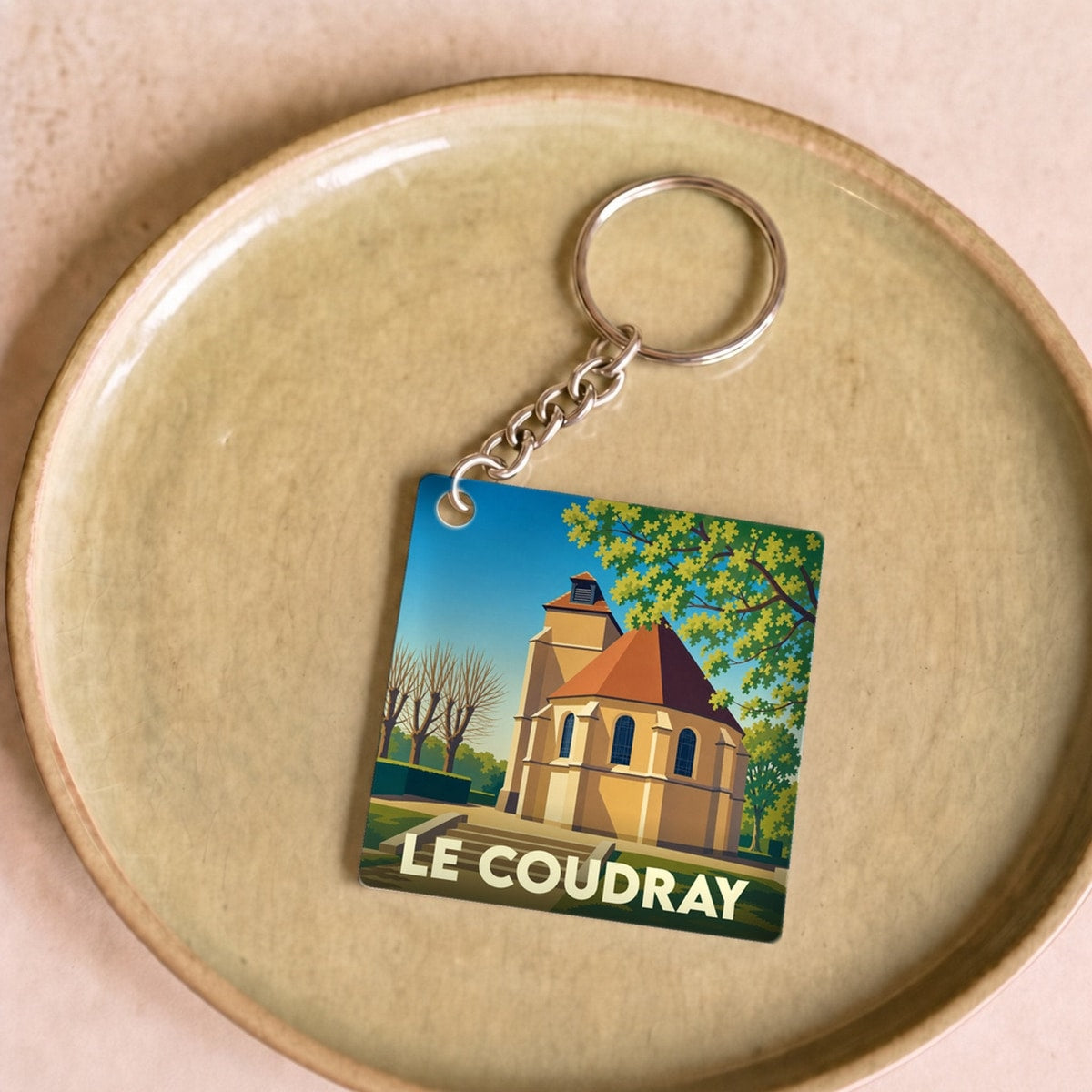 Porte-clés souvenir de la ville de Le Coudray avec une illustration stylisée de son église.