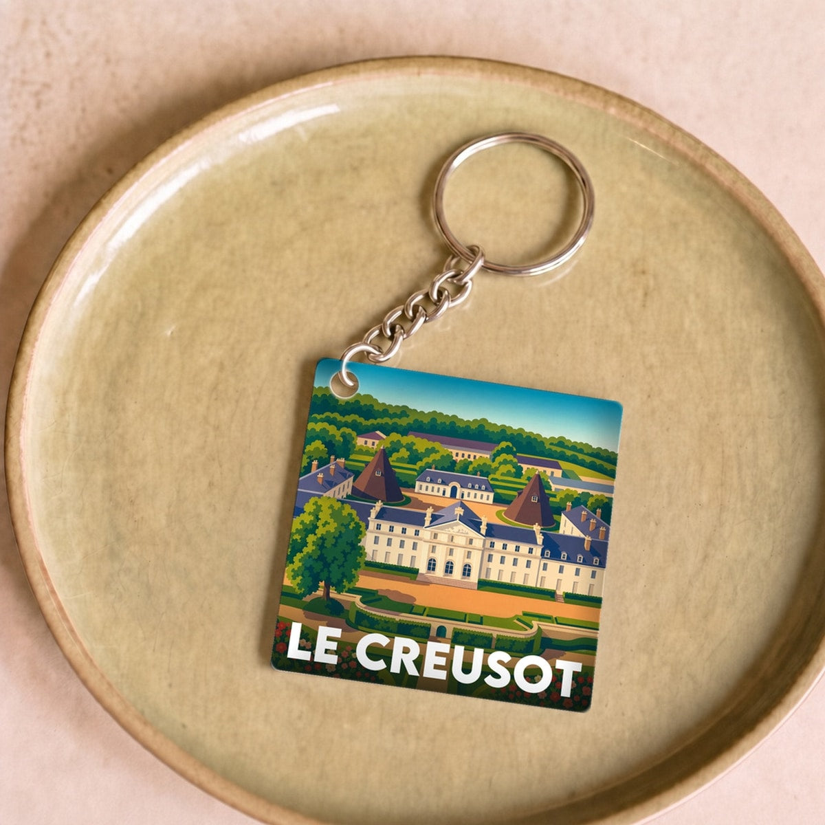 Porte-clés souvenir de la ville de Le Creusot avec une illustration stylisée.