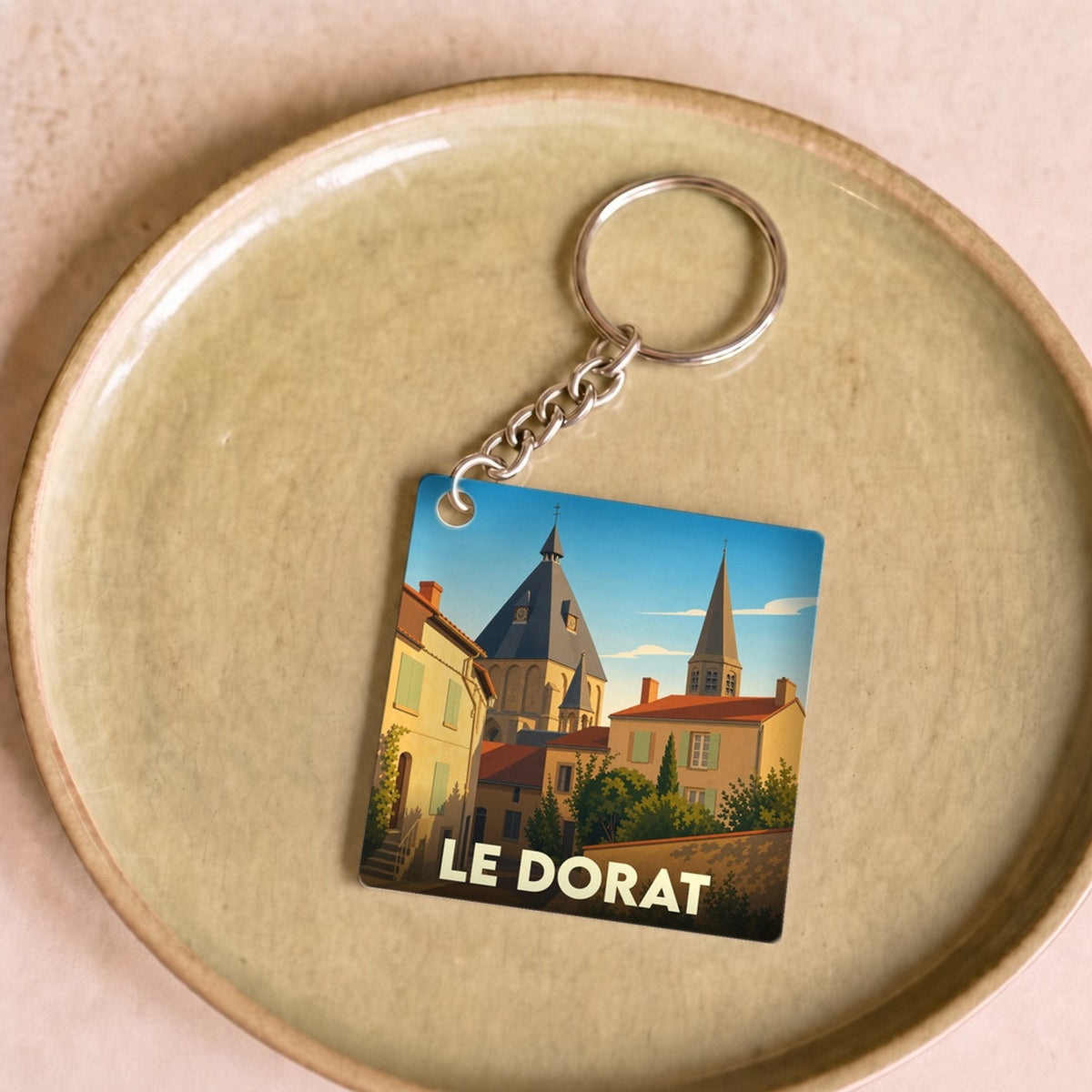 Porte-clés souvenir de la ville du Dorat avec une illustration stylisée de son église.