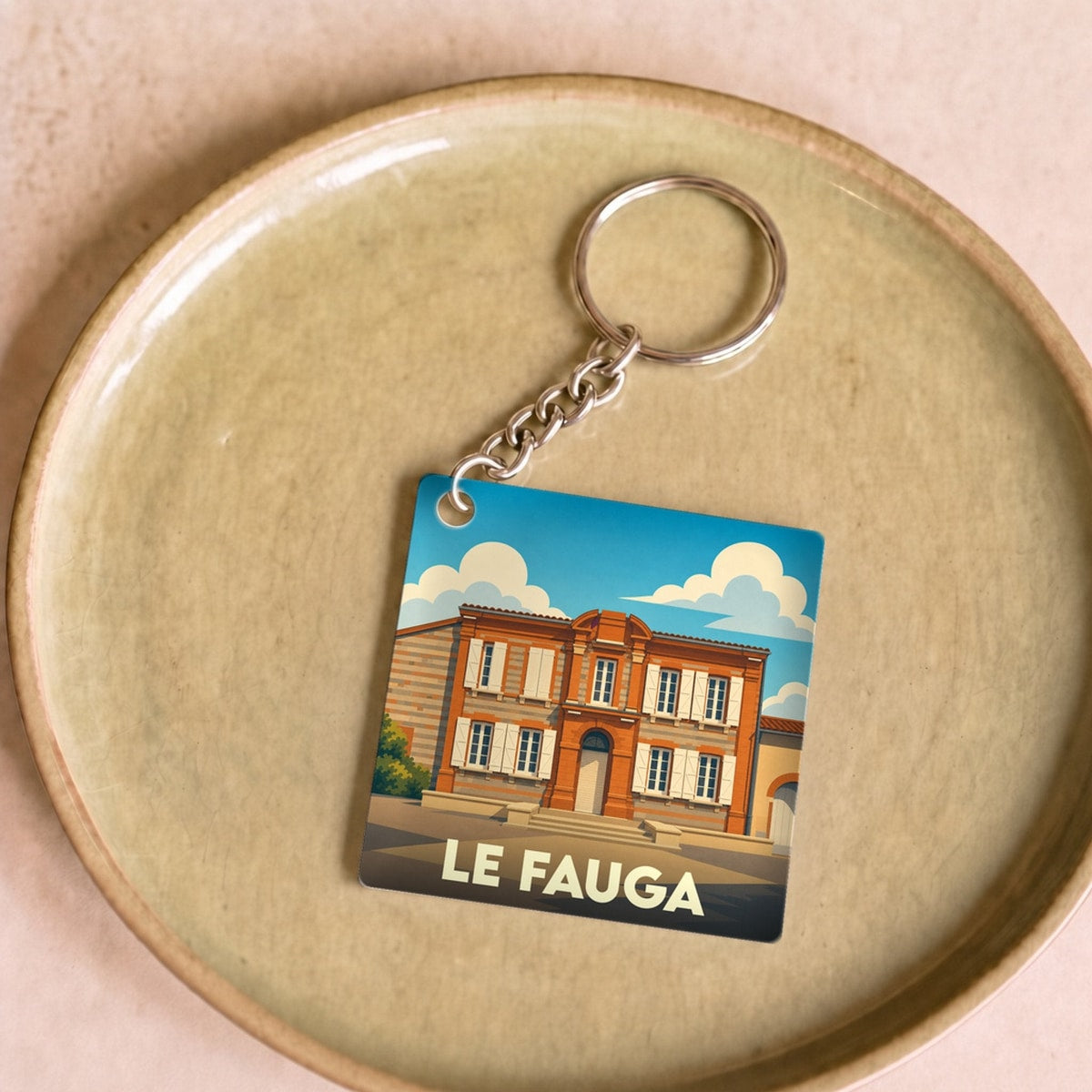 Porte-clés souvenir de la ville de Le Fauga avec une illustration stylisée de son patrimoine.