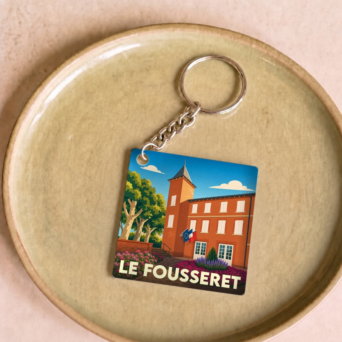 Porte-clés souvenir de la ville de Le Fousseret avec une illustration stylisée de sa mairie.