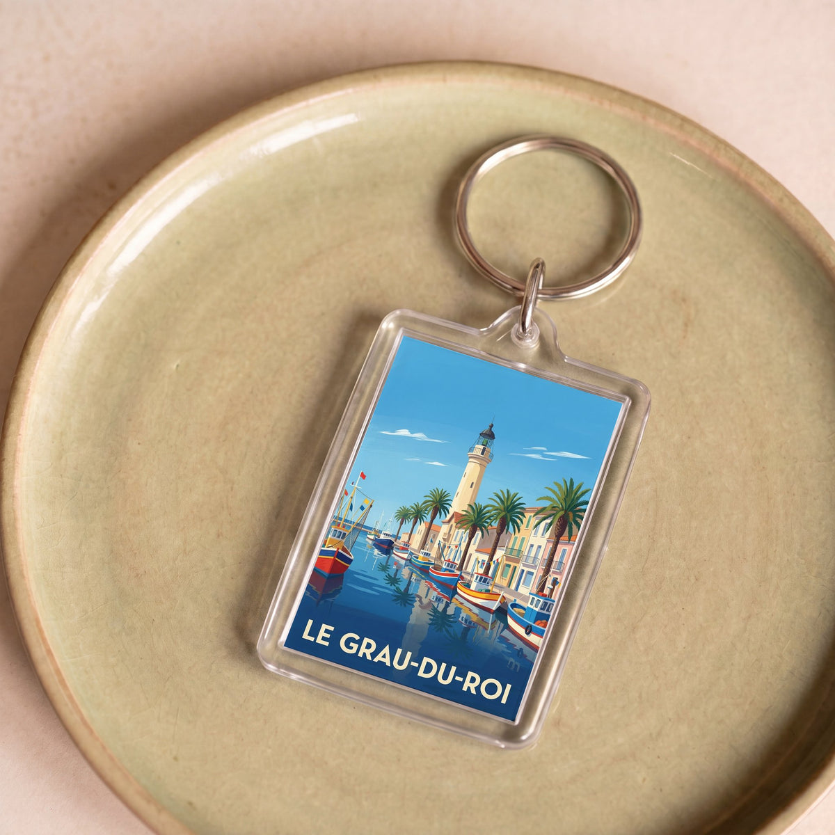 Porte-clés souvenir de la ville du Grau-du-Roi avec une illustration stylisée.