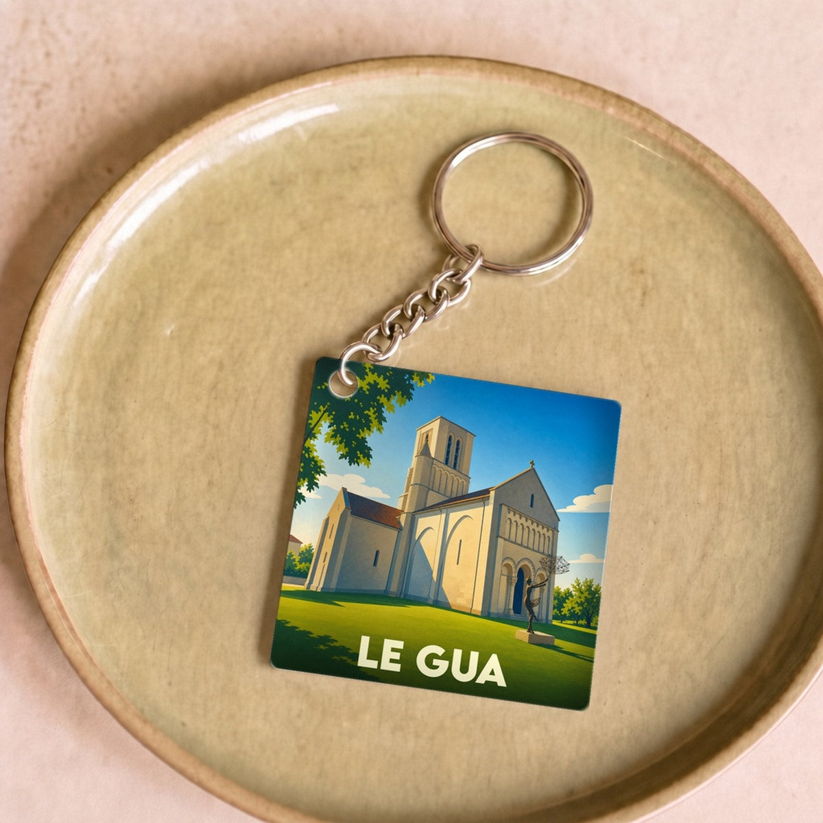 Porte-clés souvenir de la ville de Le Gua avec une illustration stylisée de son église.