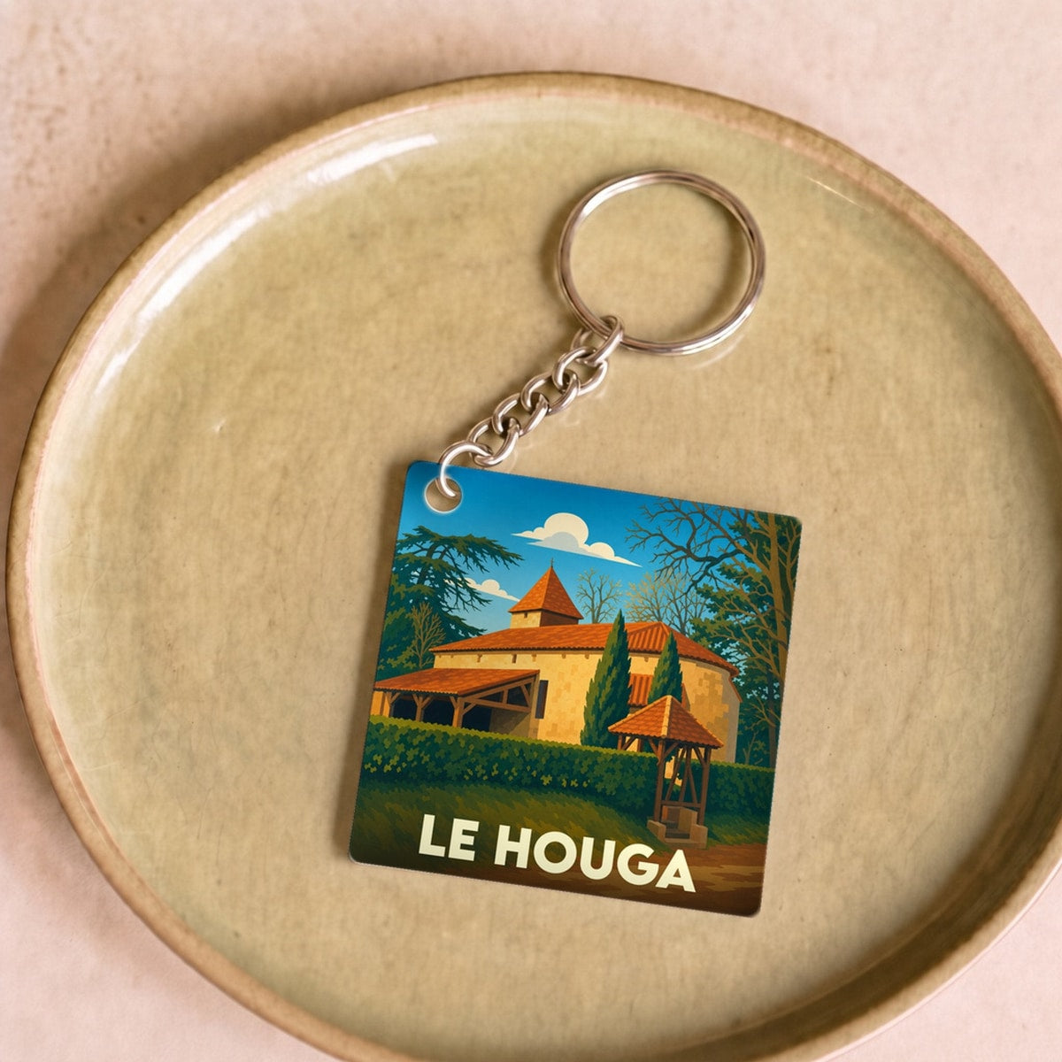 Porte-clés souvenir de la ville de Le Houga avec une illustration stylisée.