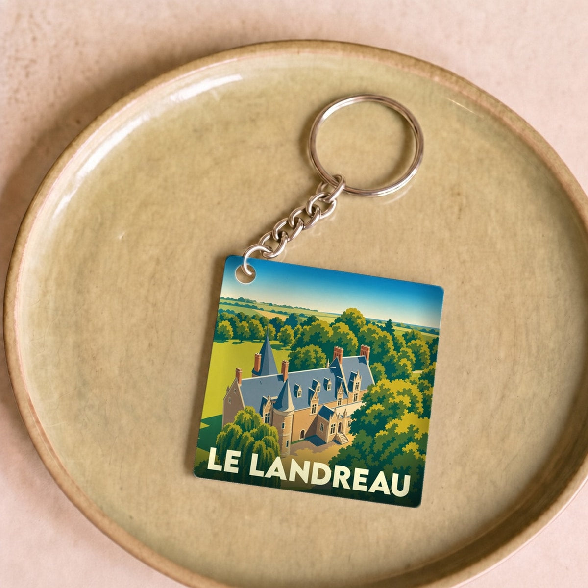 Porte-clés souvenir de la ville de Le Landreau avec une illustration stylisée.