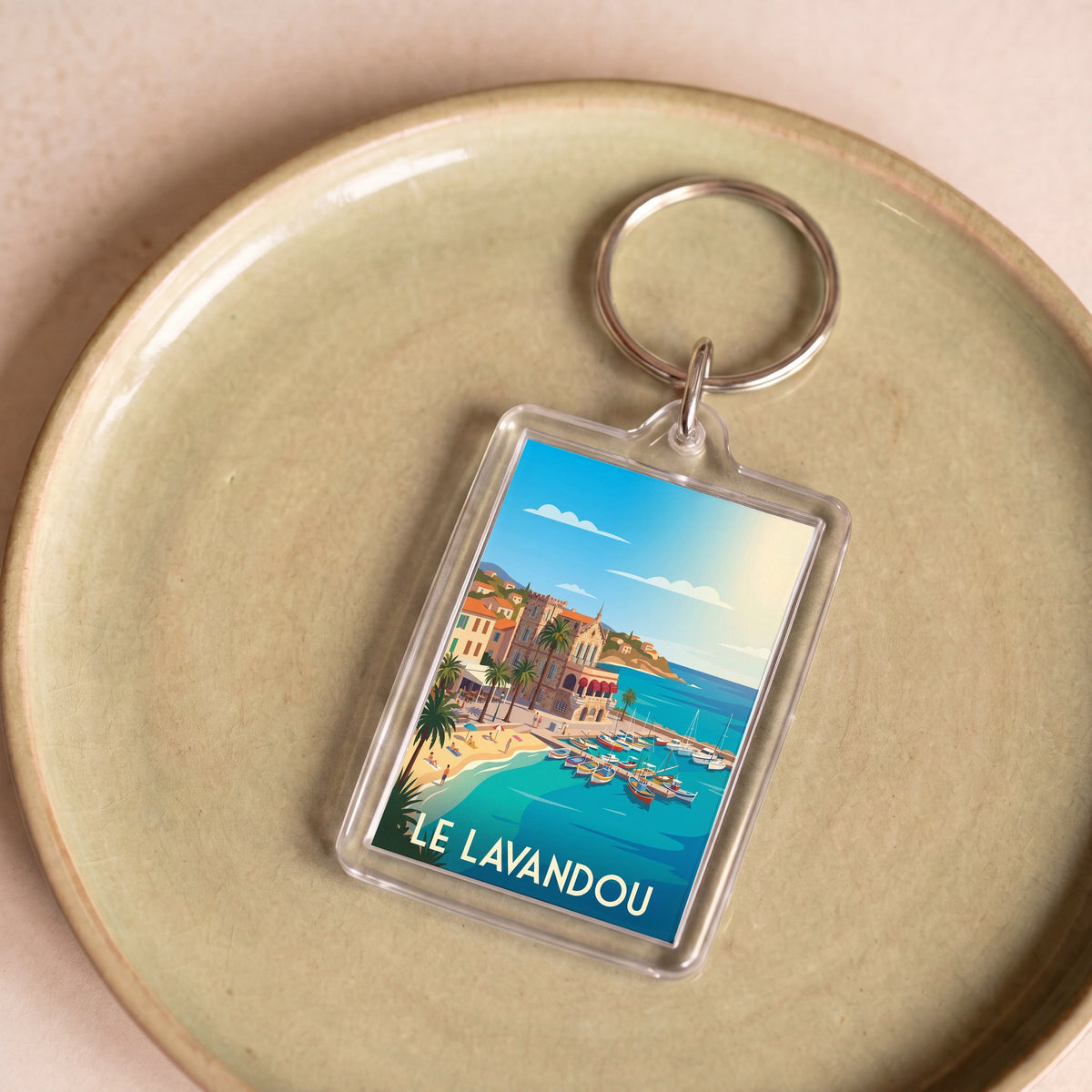 Porte-clés souvenir de la ville de Le Lavandou avec une illustration stylisée de son bord de mer.