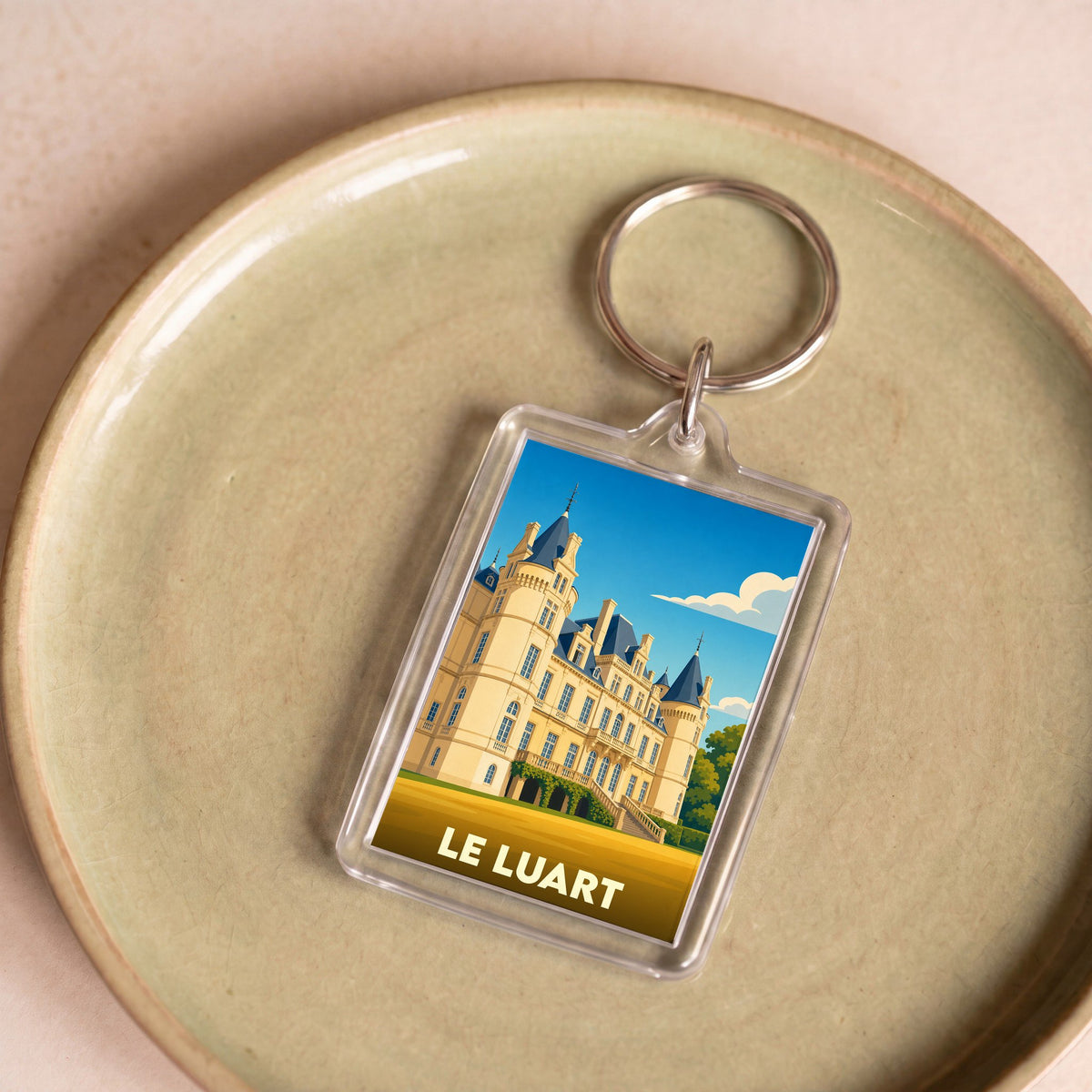 Porte-clés souvenir de la ville de Le Luart avec une illustration stylisée de son château.