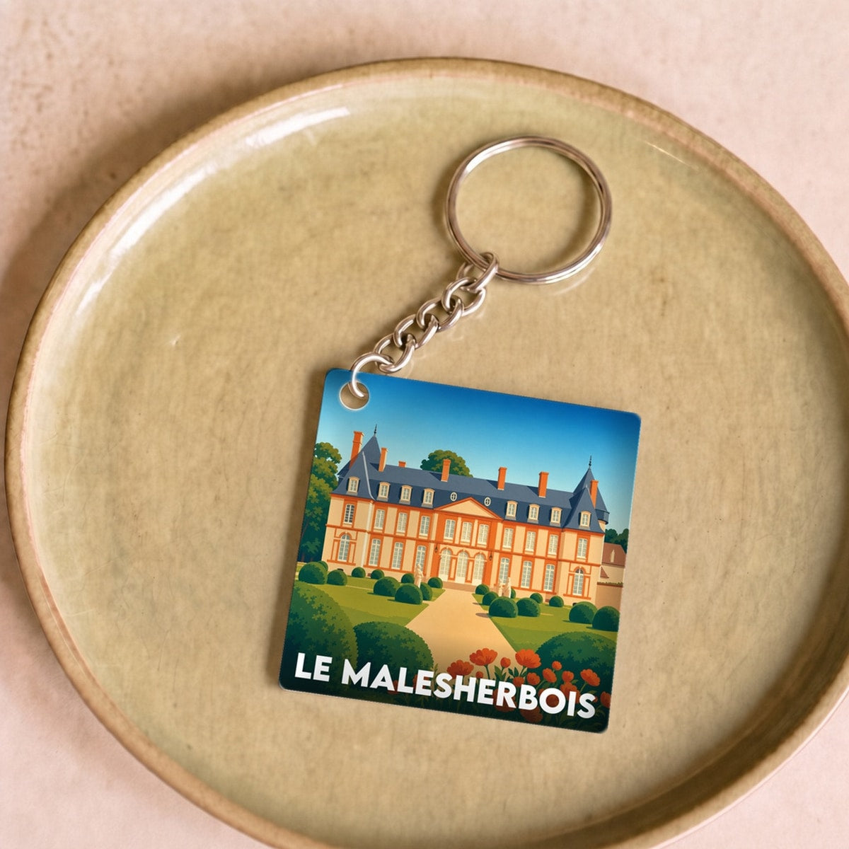 Porte-clés souvenir de la ville de Le Malesherbois avec une illustration stylisée.