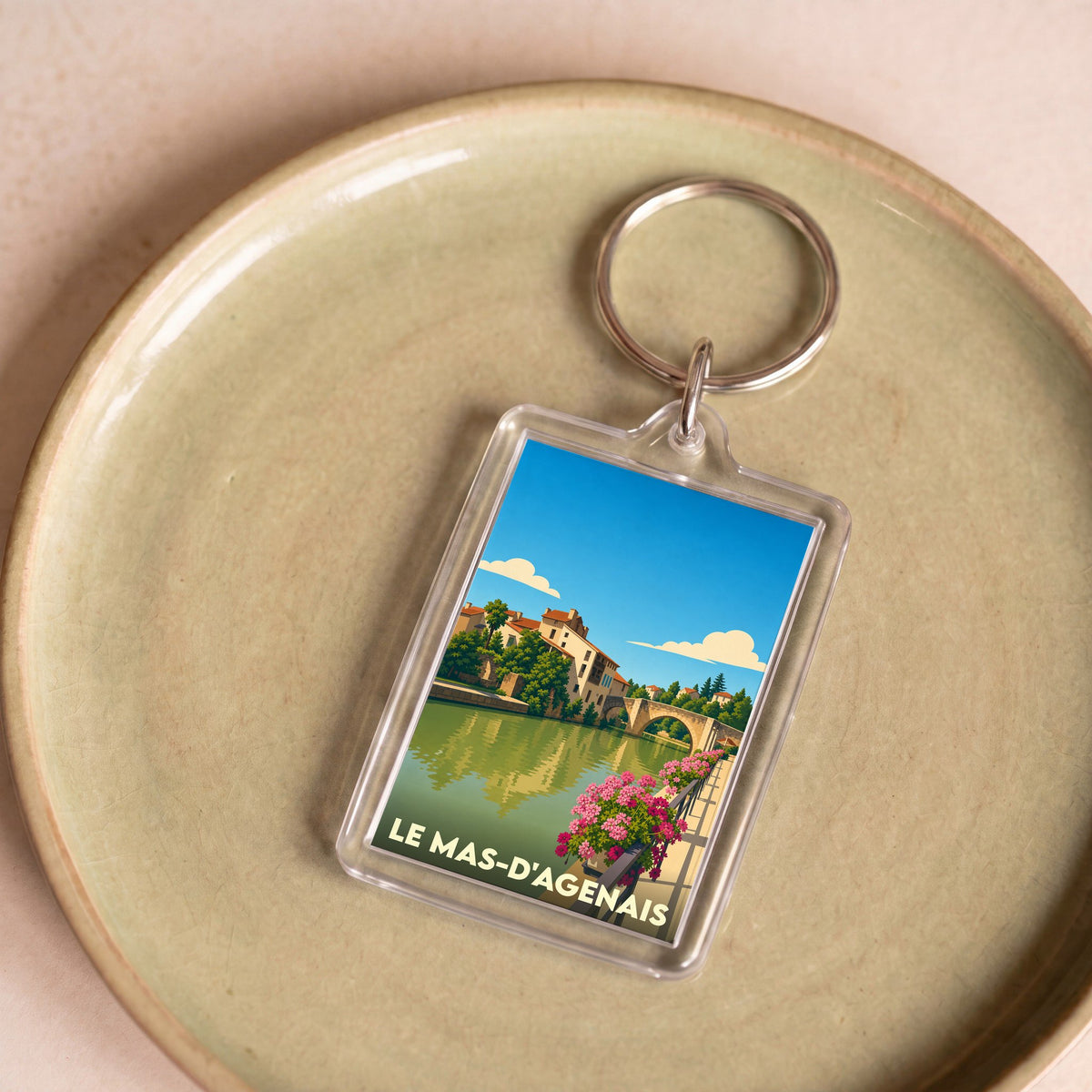 Porte-clés souvenir de la ville du Mas-d'Agenais avec une illustration stylisée.
