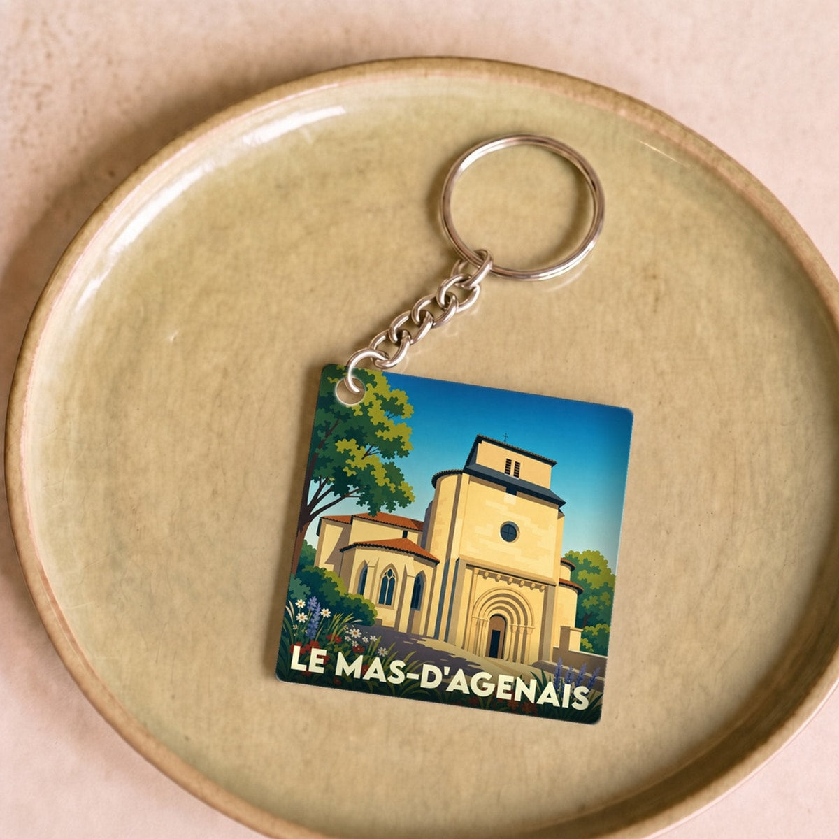 Porte-clés souvenir de la ville de Le Mas-d'Agenais avec une illustration stylisée de son église collégiale.