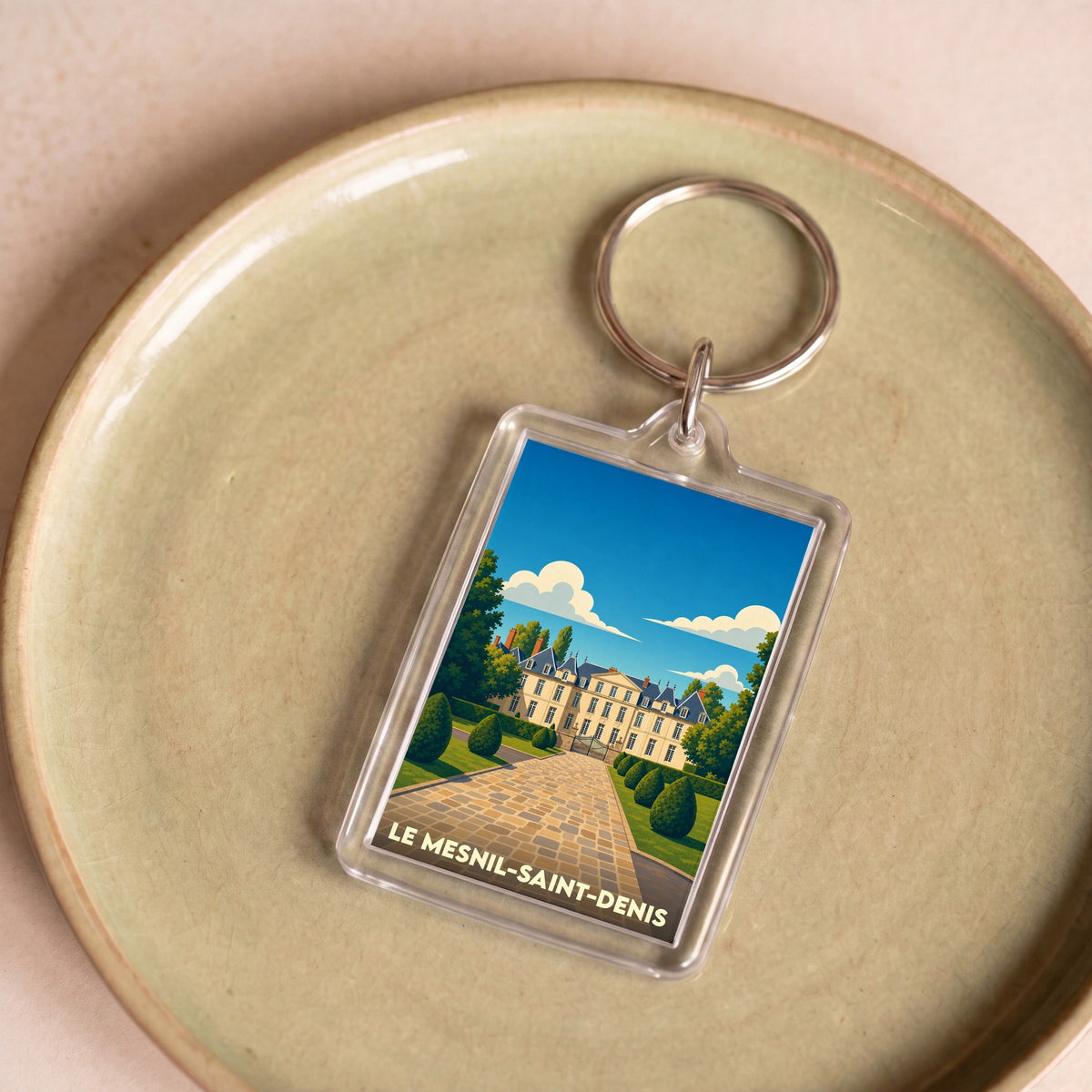 Porte-clés souvenir de la ville de Le Mesnil-Saint-Denis avec une illustration stylisée de son château.