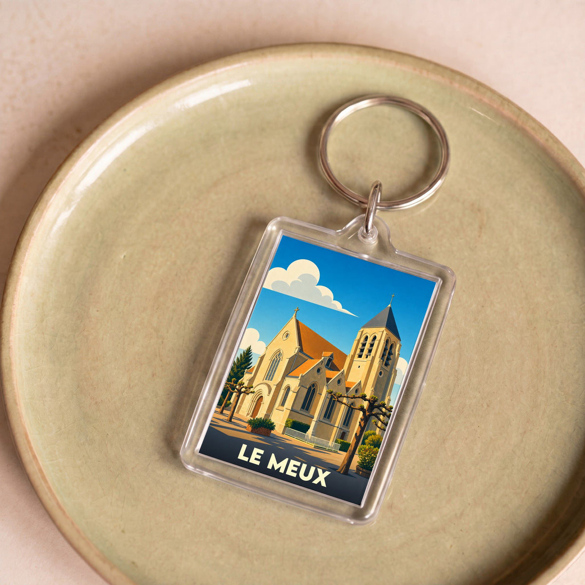 Porte-clés souvenir de la ville de Le Meux avec une illustration stylisée de son église.