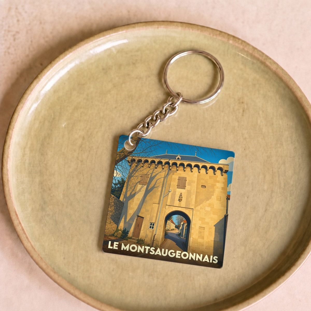 Porte-clés souvenir de la ville de Le Montsaugeonnais avec une illustration stylisée d'une porte historique.